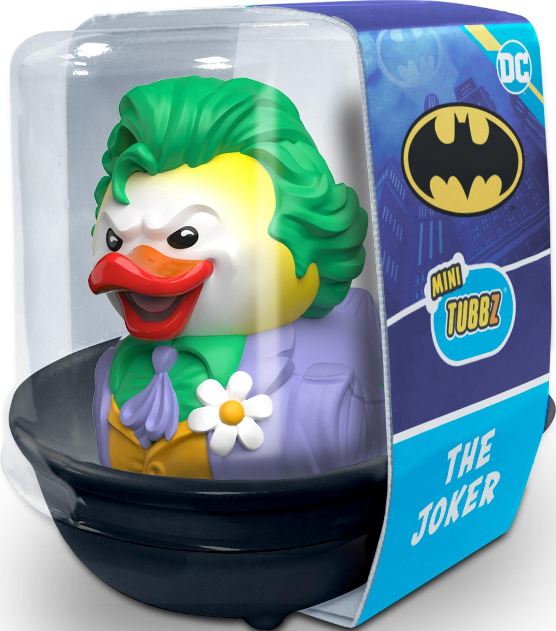 Eine Joker-Gummi-Ente mit grünen Haaren, gelbem Gesicht und lila Anzug im Karton.