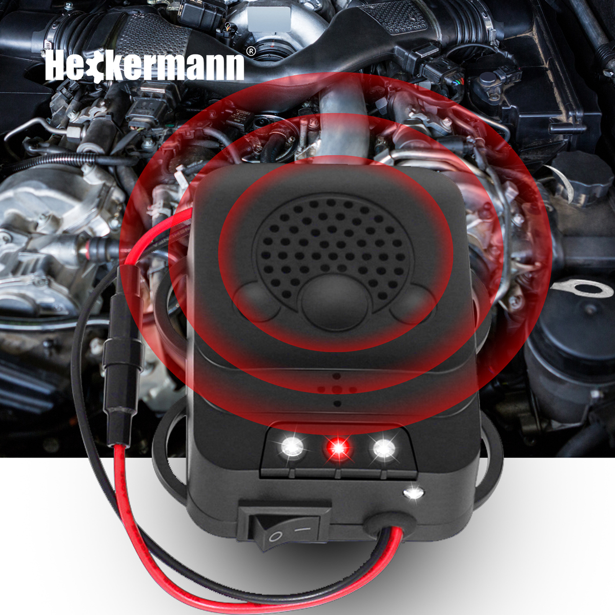 Czarne urządzenie z czerwonymi pierścieniami przed silnikiem. Wychodzą dwa kable.