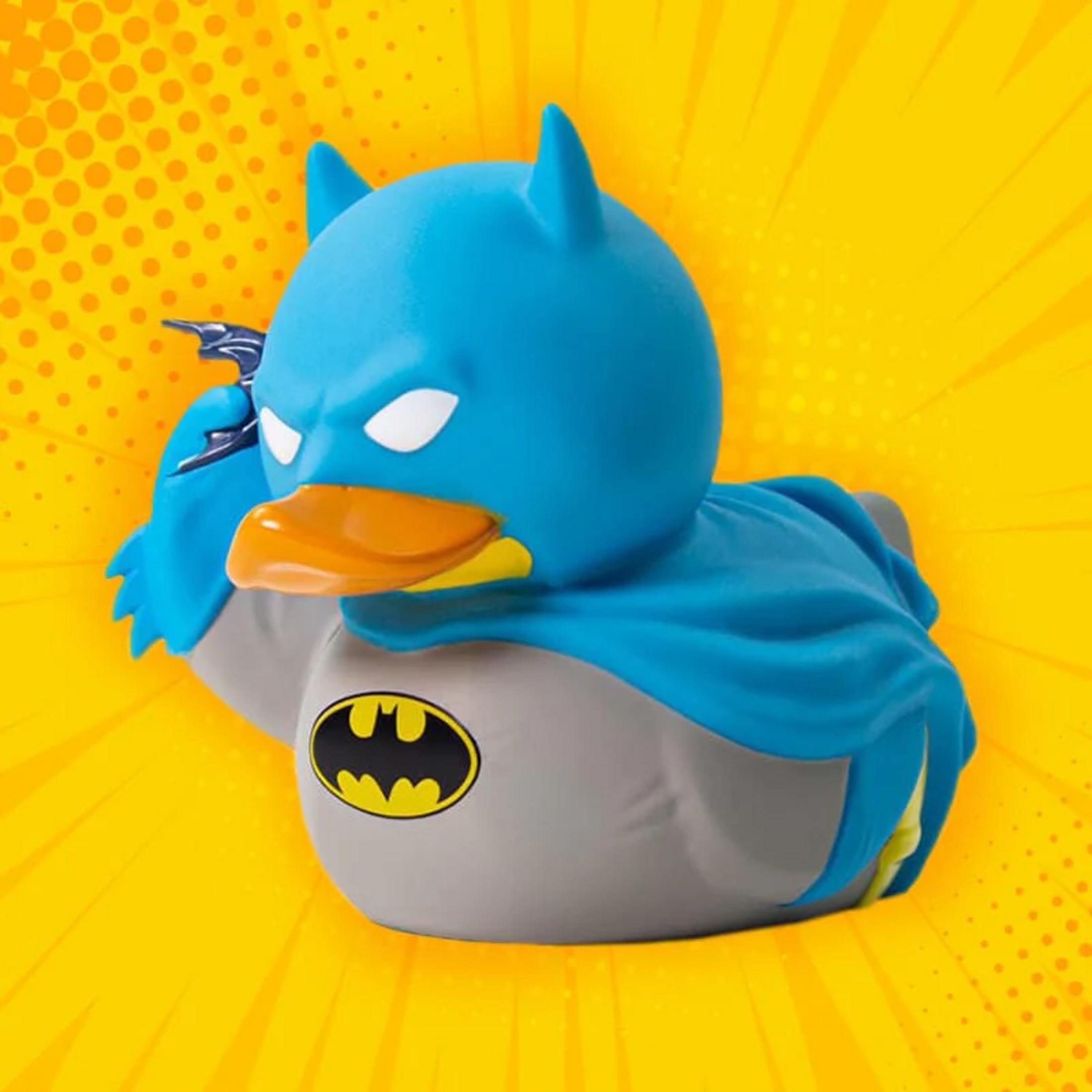 Ein Batman-Gummikentchen mit blauem Cape und gelbem Logo auf gelbem Hintergrund.