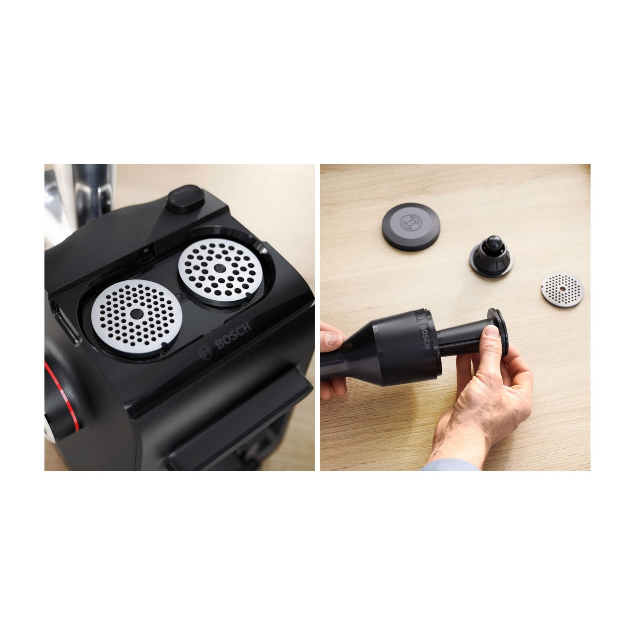 Zbliżenie przystawki do maszynki do mięsa z dwoma tarczami i ręką montującą.