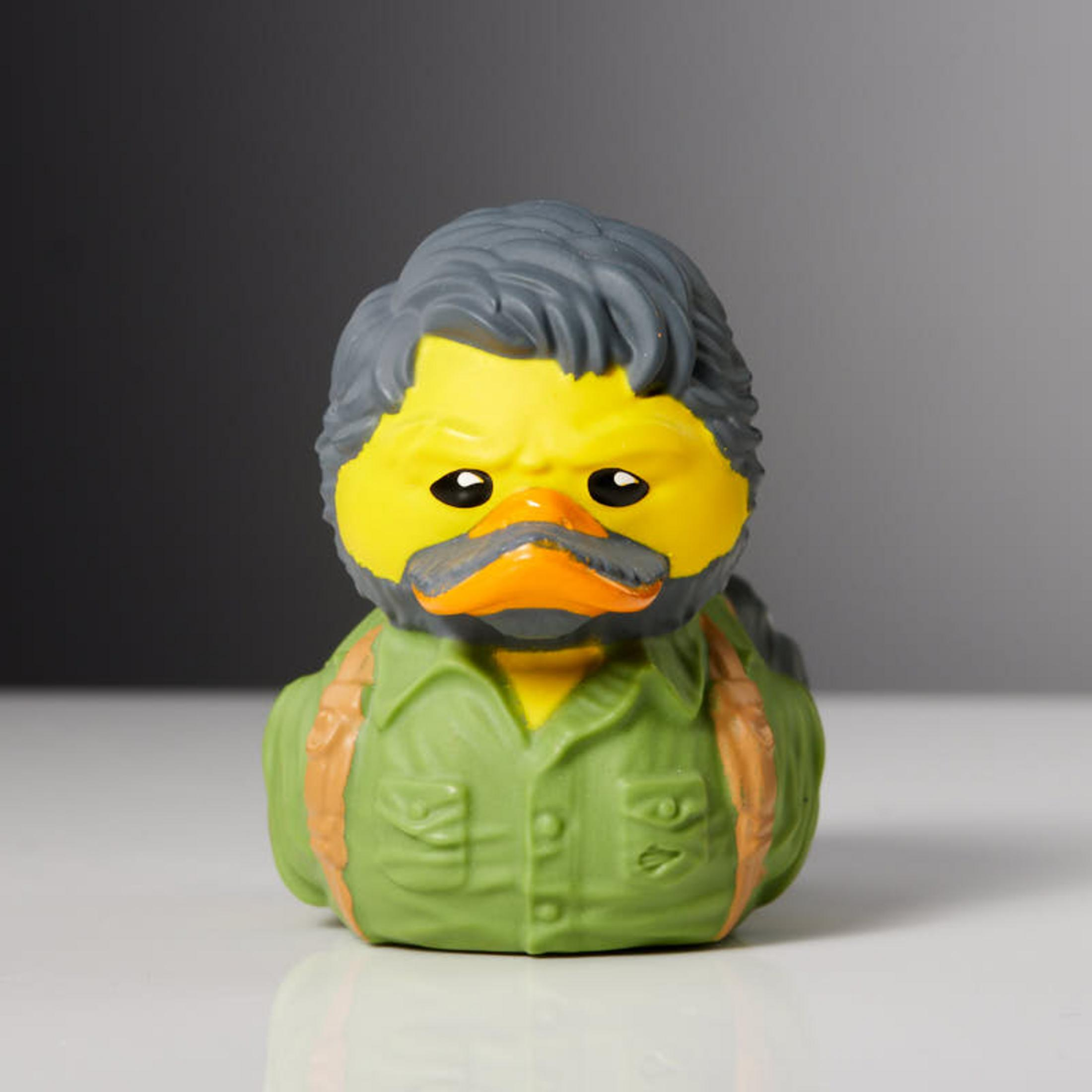 Gelber Quietscheentchen-Figur mit grauer Perücke, Bart und grünem Hemd.