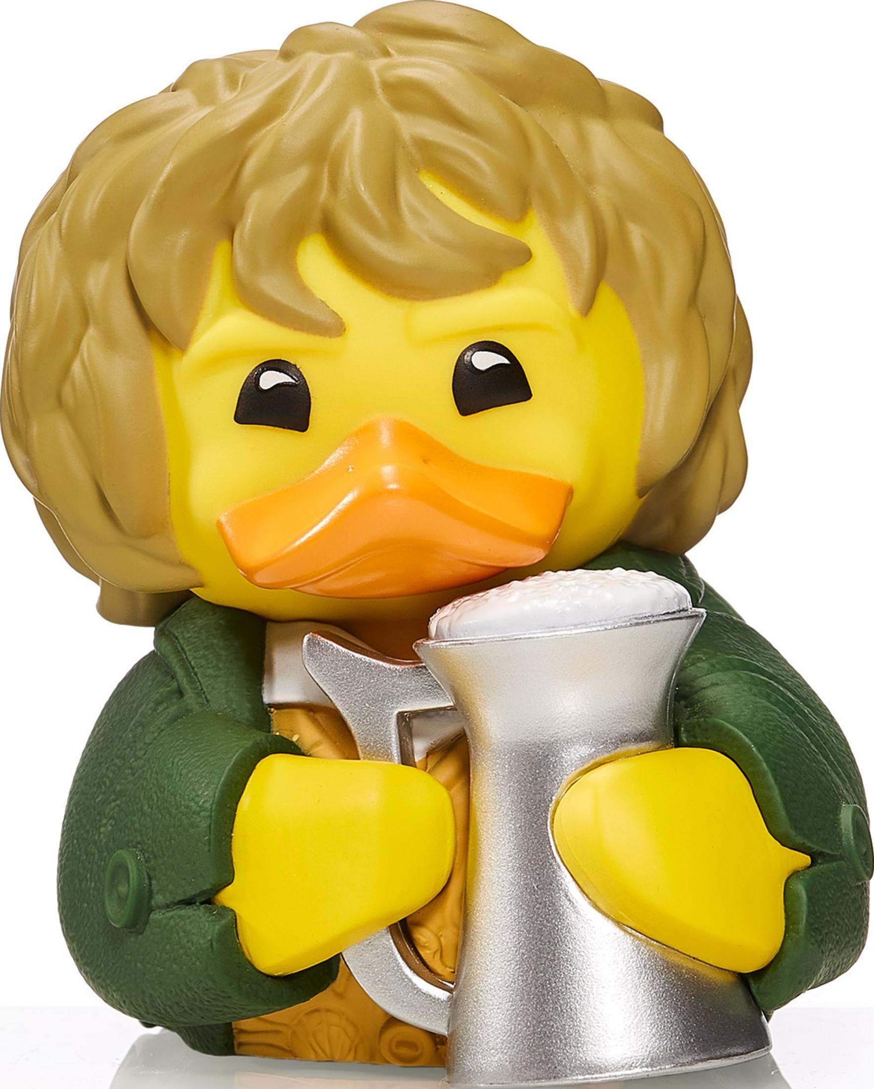 Eine gelbe Gummiente mit braunem Haar und grünem Hemd hält einen silbernen Becher mit weißem Schaum.