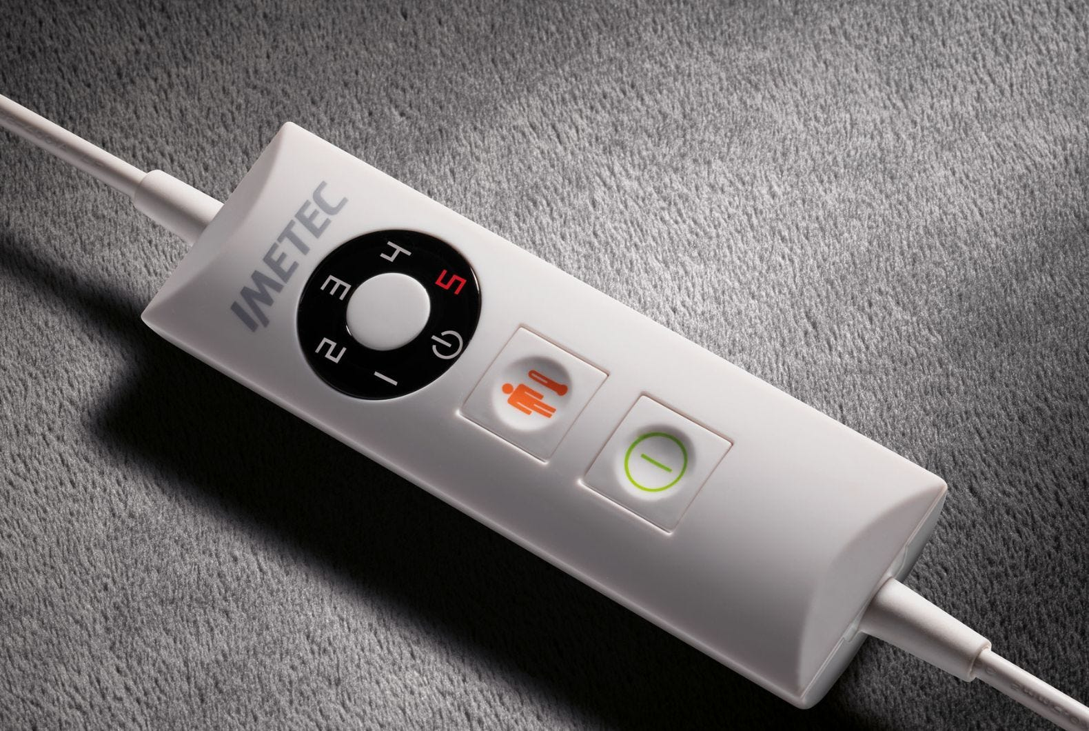 Un controller Imetec bianco con pulsanti per calore e potenza su tessuto grigio.