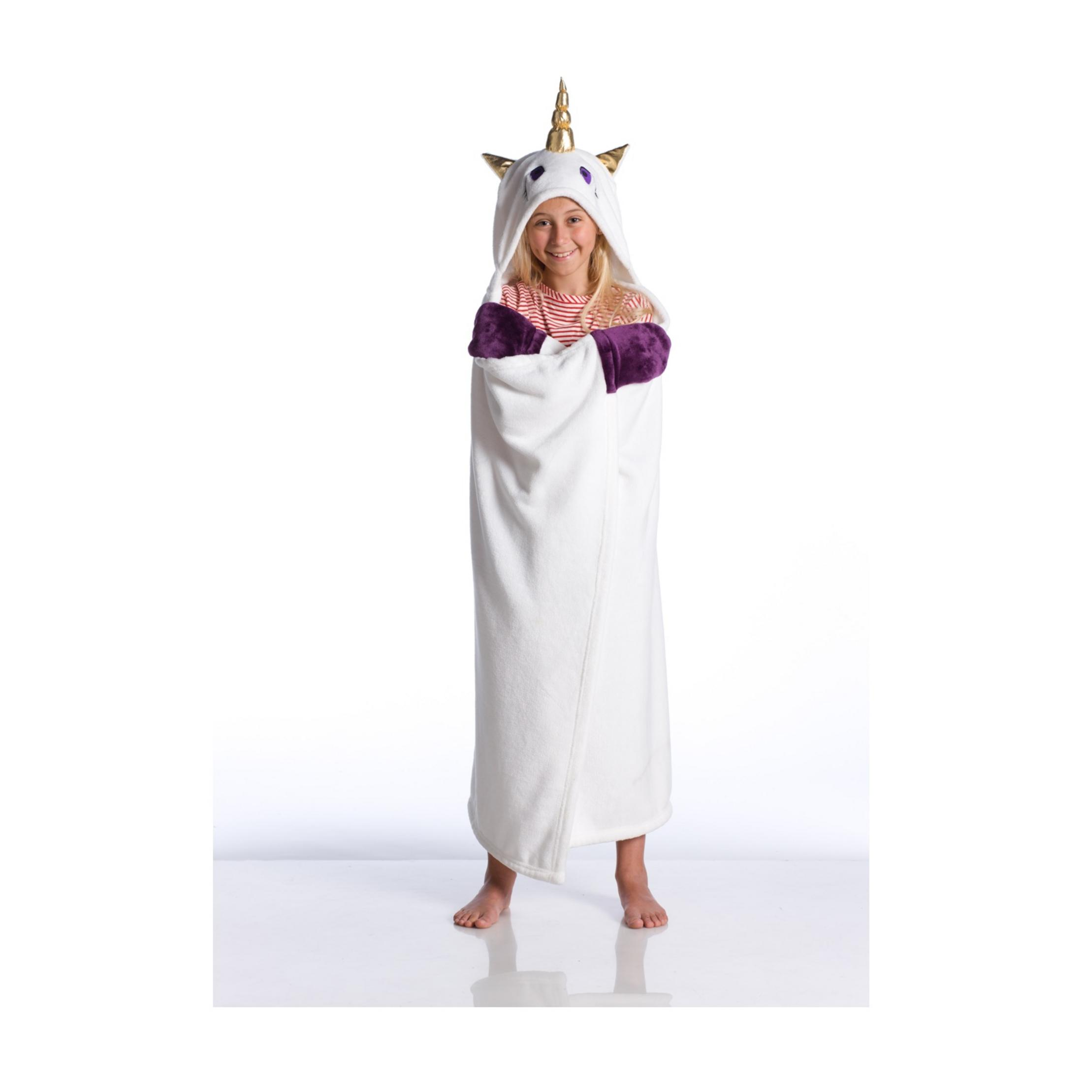 Una bambina sorridente in un accappatoio bianco da unicorno con maniche viola.