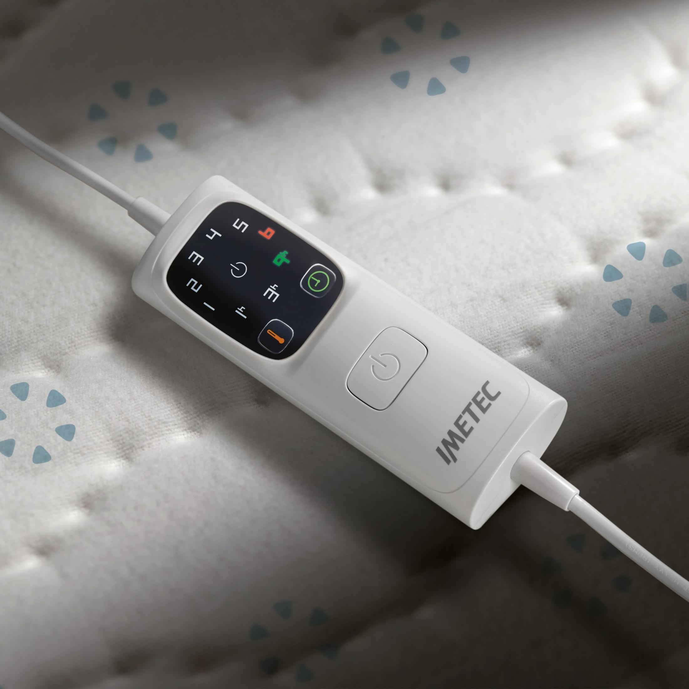 Un controller bianco per coperta elettrica con display e pulsanti su una coperta.