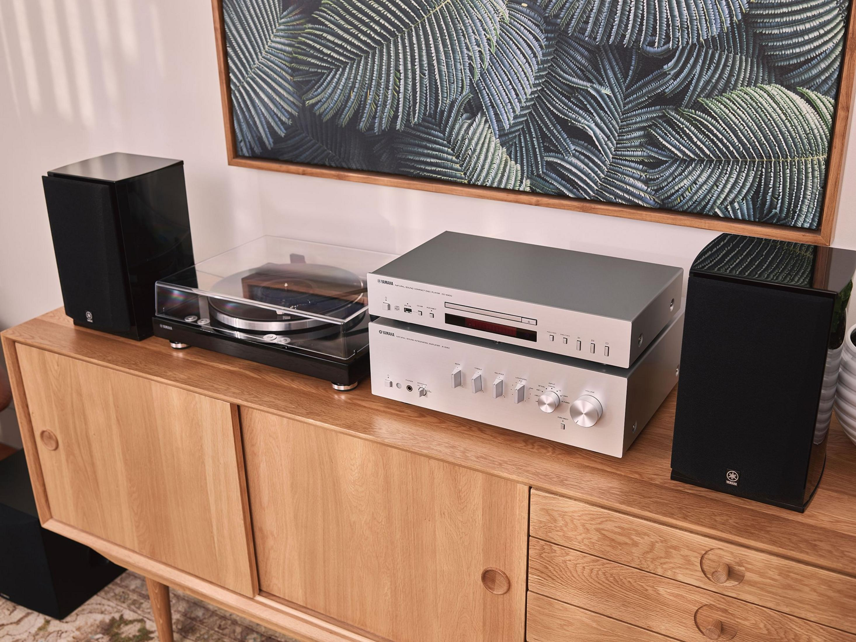Un giradischi, un lettore CD e un amplificatore su un mobile in legno.