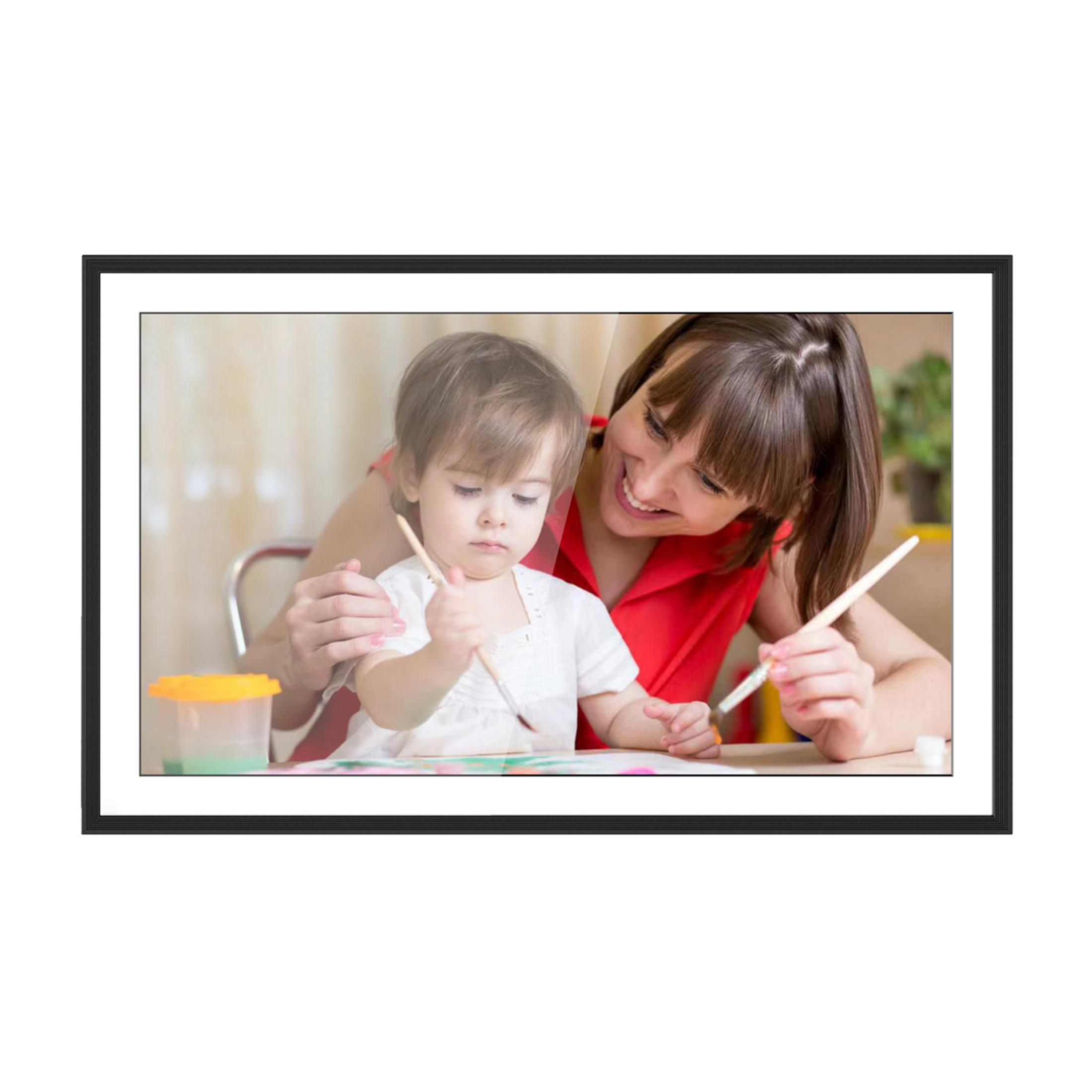 Donna e bambino dipingono con pennelli su carta a un tavolo.