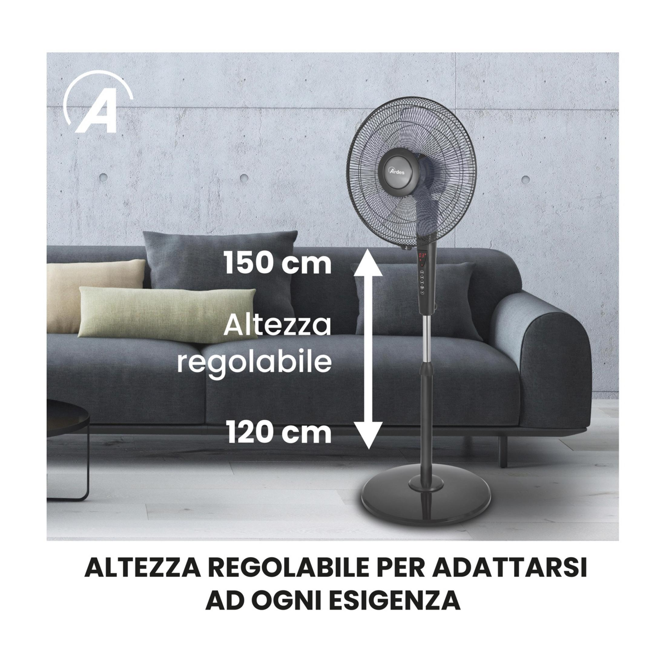 Czarny wentylator stojący z regulowaną wysokością stoi obok szarej sofy.