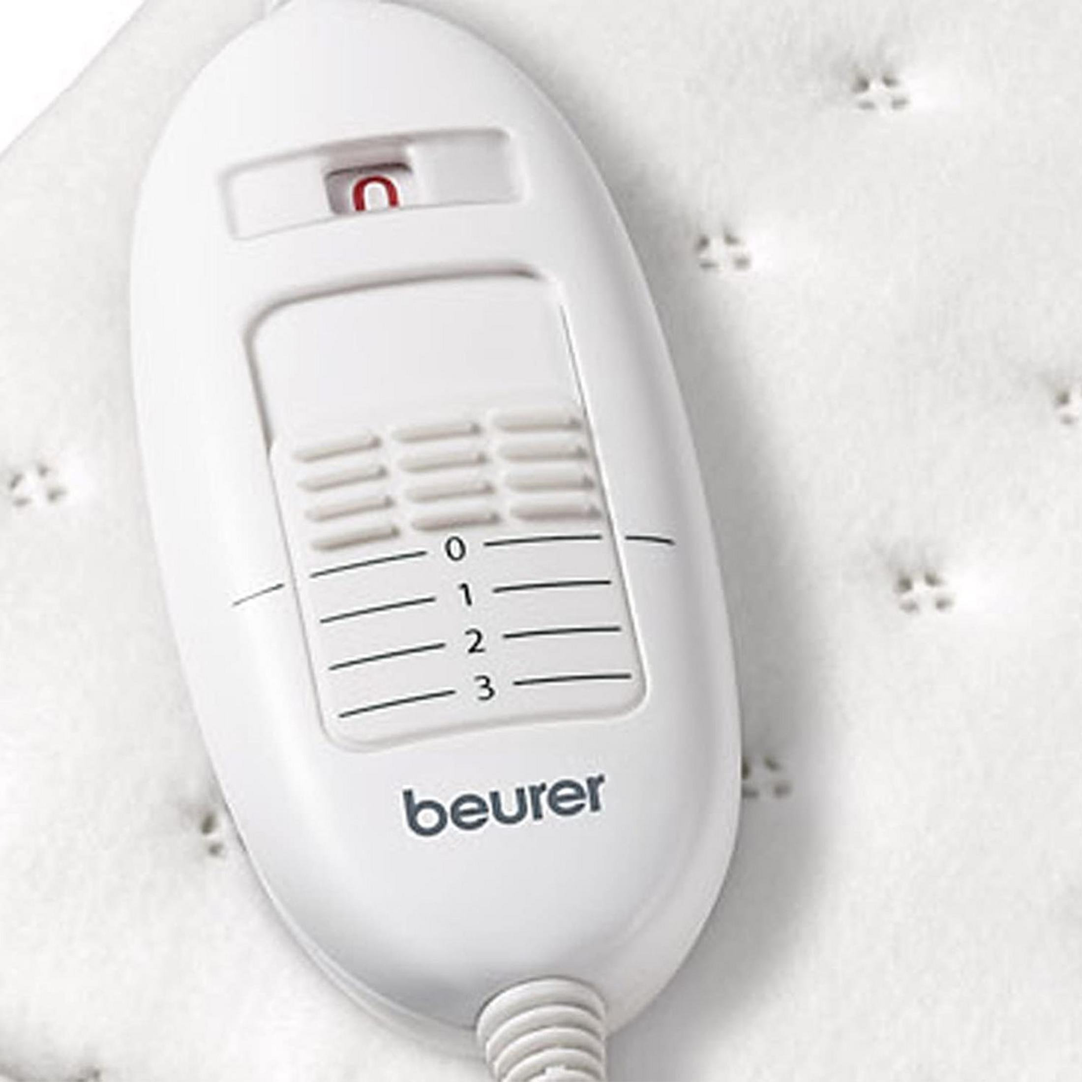 Un controller bianco per coperta termica Beurer con impostazioni 0-3 e interruttore rosso.