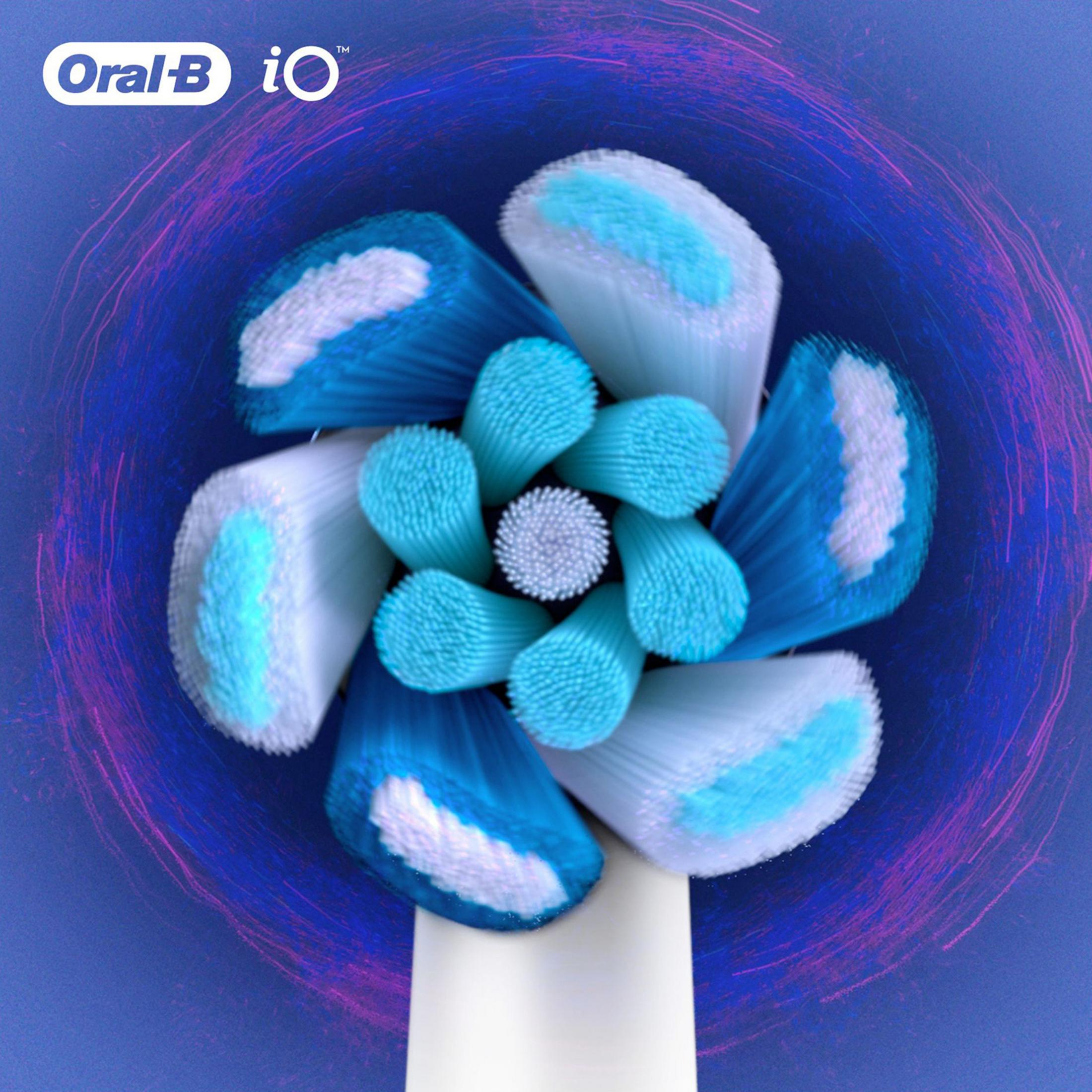 Primer plano de un cabezal de cepillo de dientes eléctrico con cerdas azules y blancas sobre fondo azul.