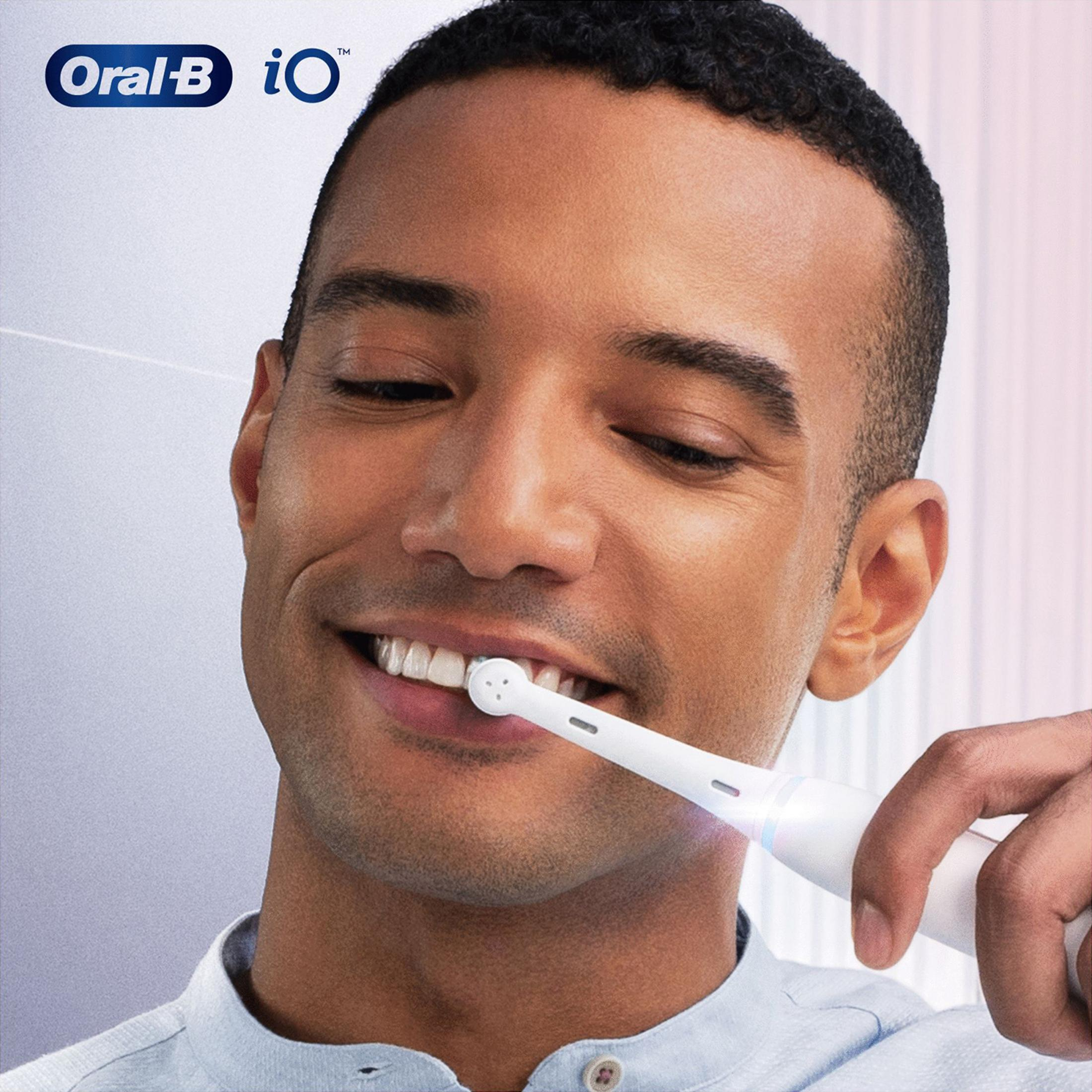 Mann putzt sich die Zähne mit elektrischer Zahnbürste. Oral-B iO Logo.