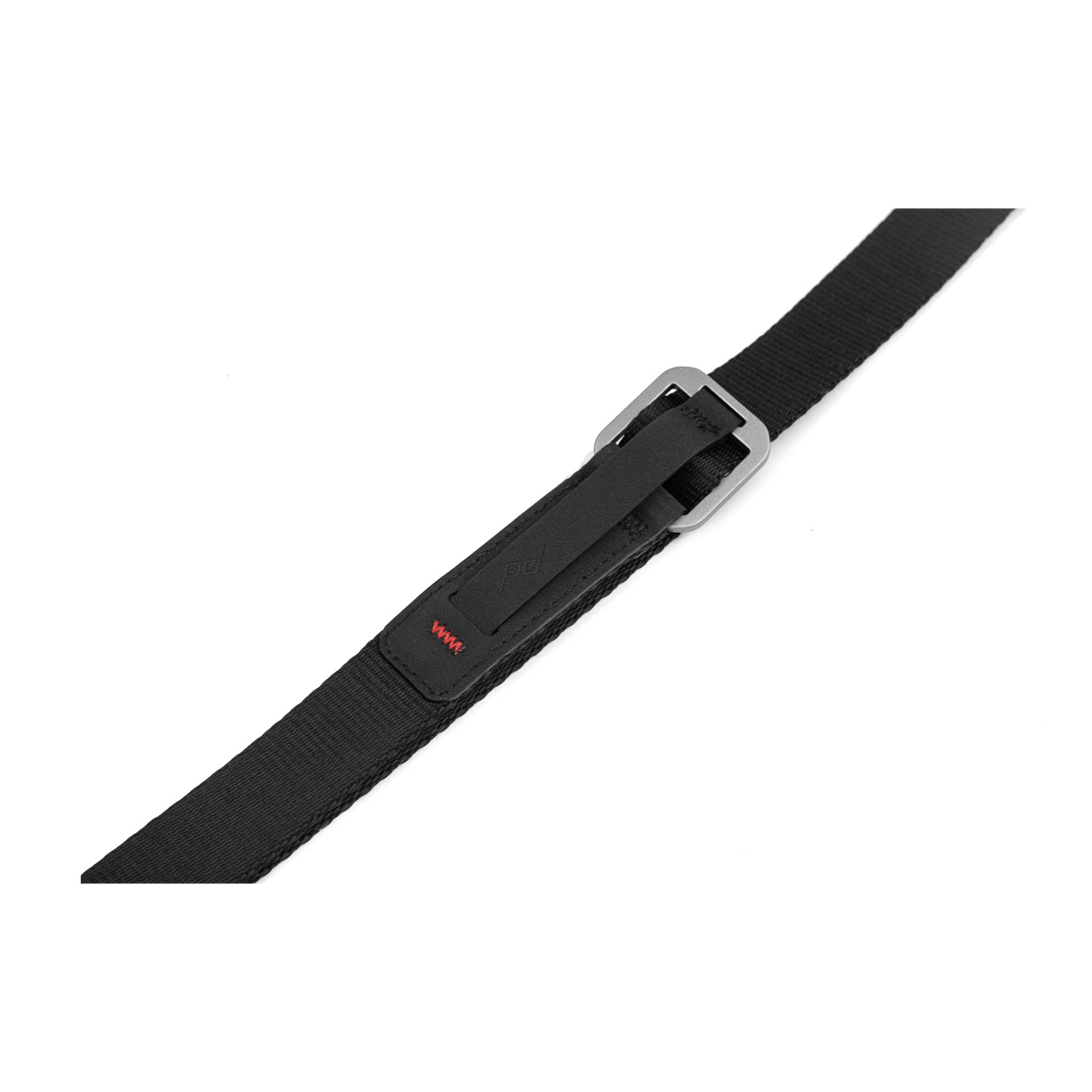 Sangle noire avec boucle métallique et écusson logo avec surpiqûre rouge.