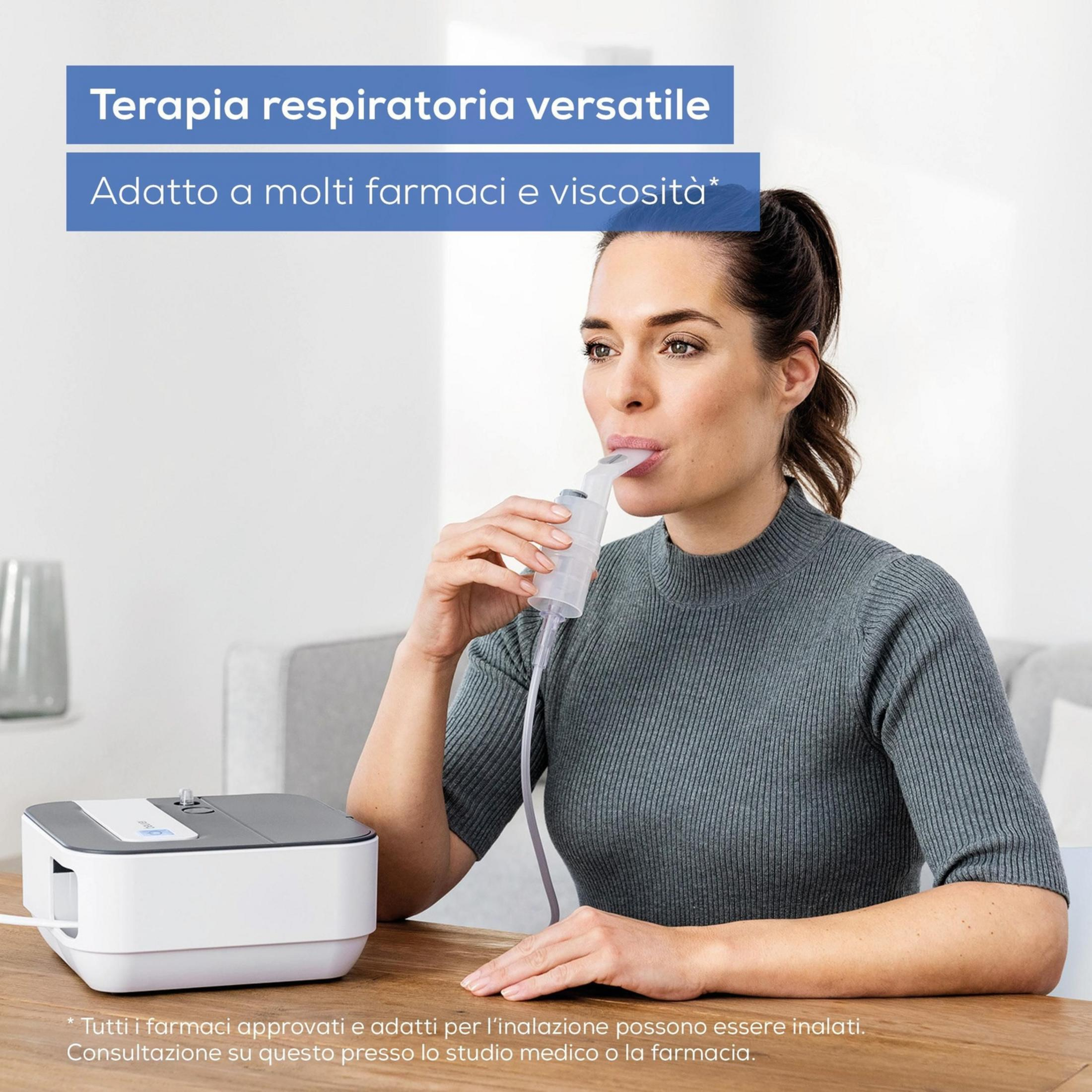 Een vrouw gebruikt een inhalator. Een apparaat staat op tafel.
