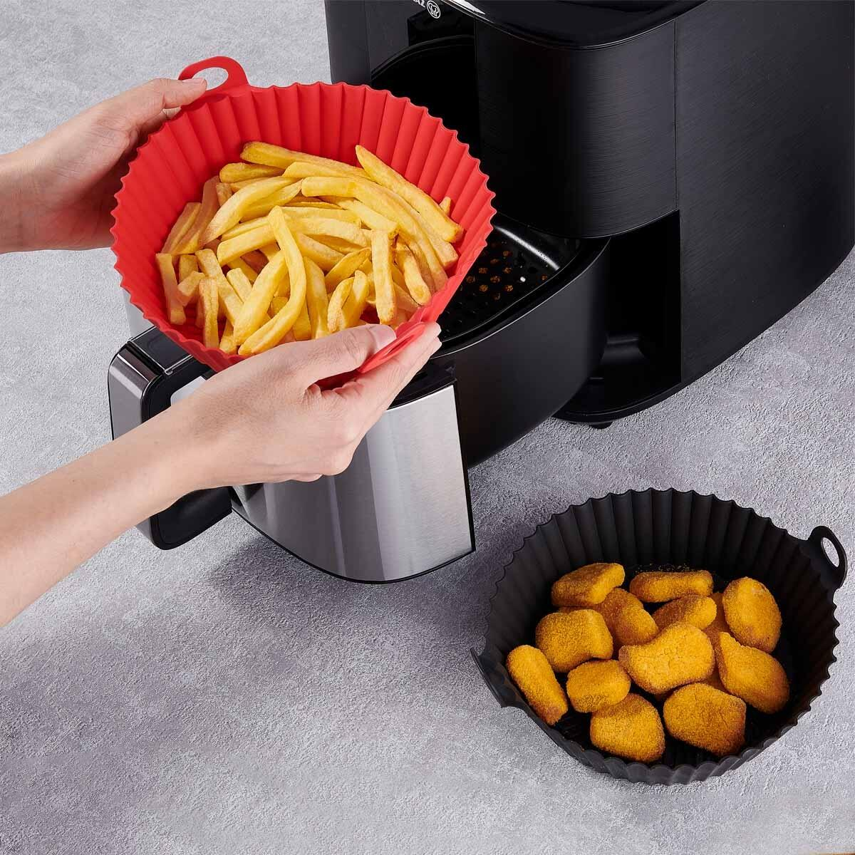 Kırmızı silikon hazne, air fryer sepetine konulan patates kızartması.