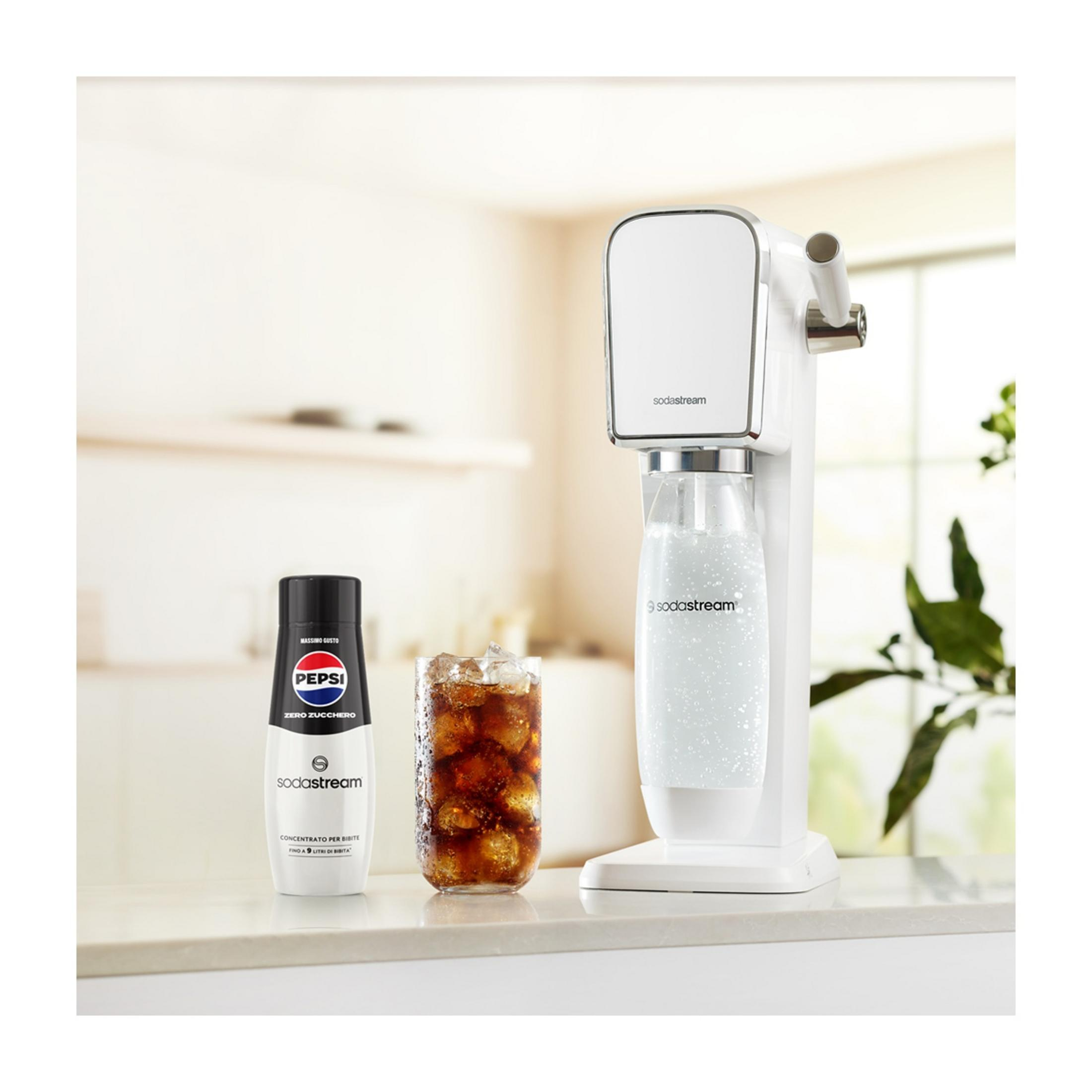 Ein SodaStream-Gerät mit einer Pepsi-Flasche und einem Glas Cola mit Eis.