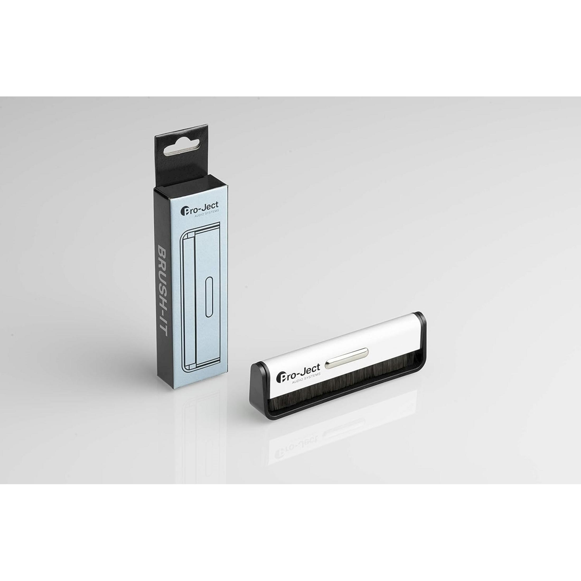 Czarno-biała szczotka do czyszczenia płyt obok opakowania.