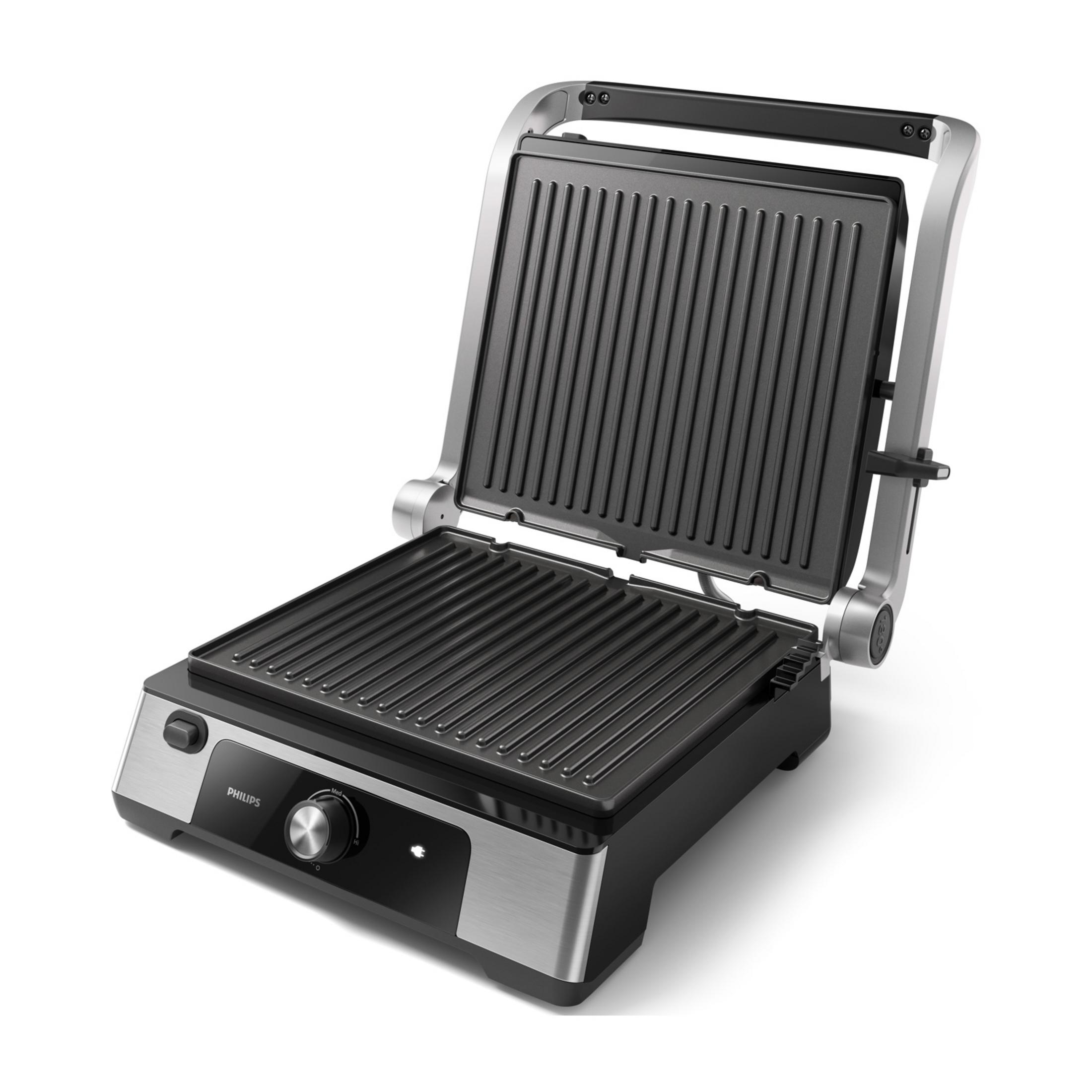 Ein offener Kontaktgrill mit gerippten Platten und einem silbernen Griff.