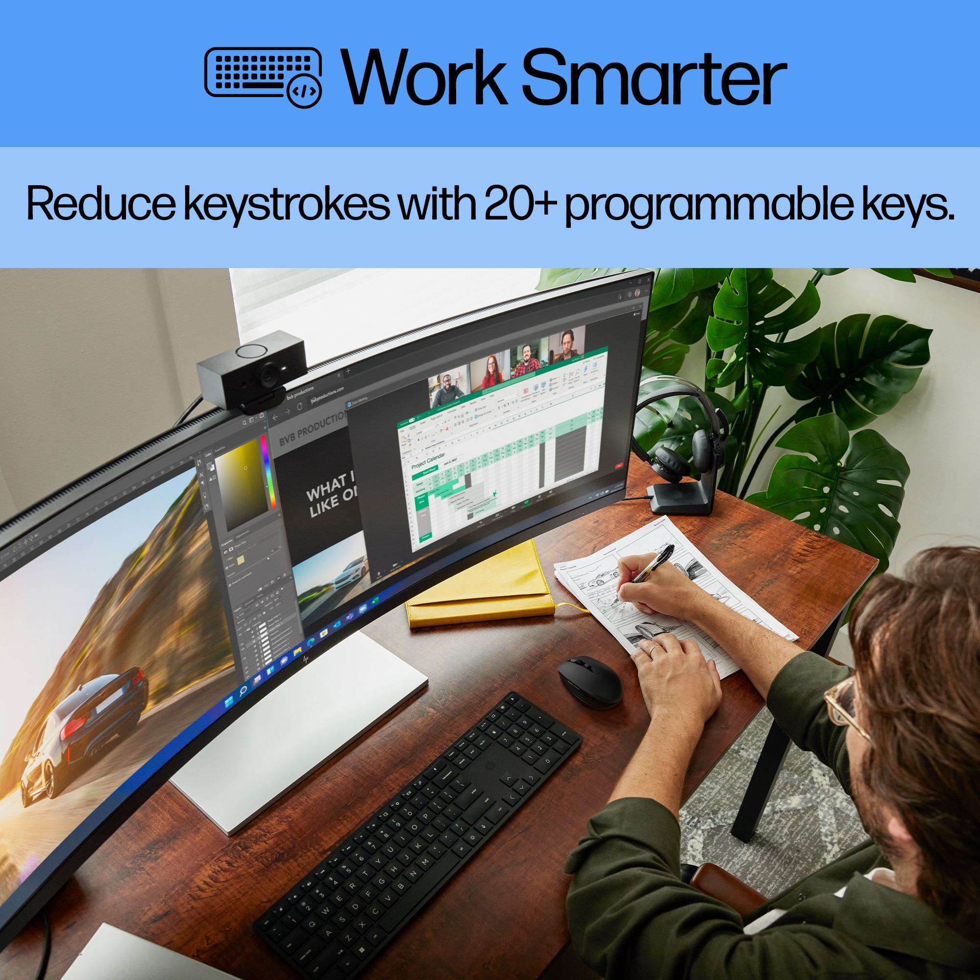 Ein Mann arbeitet am Schreibtisch mit einem großen Monitor, einer Tastatur und einer Maus.