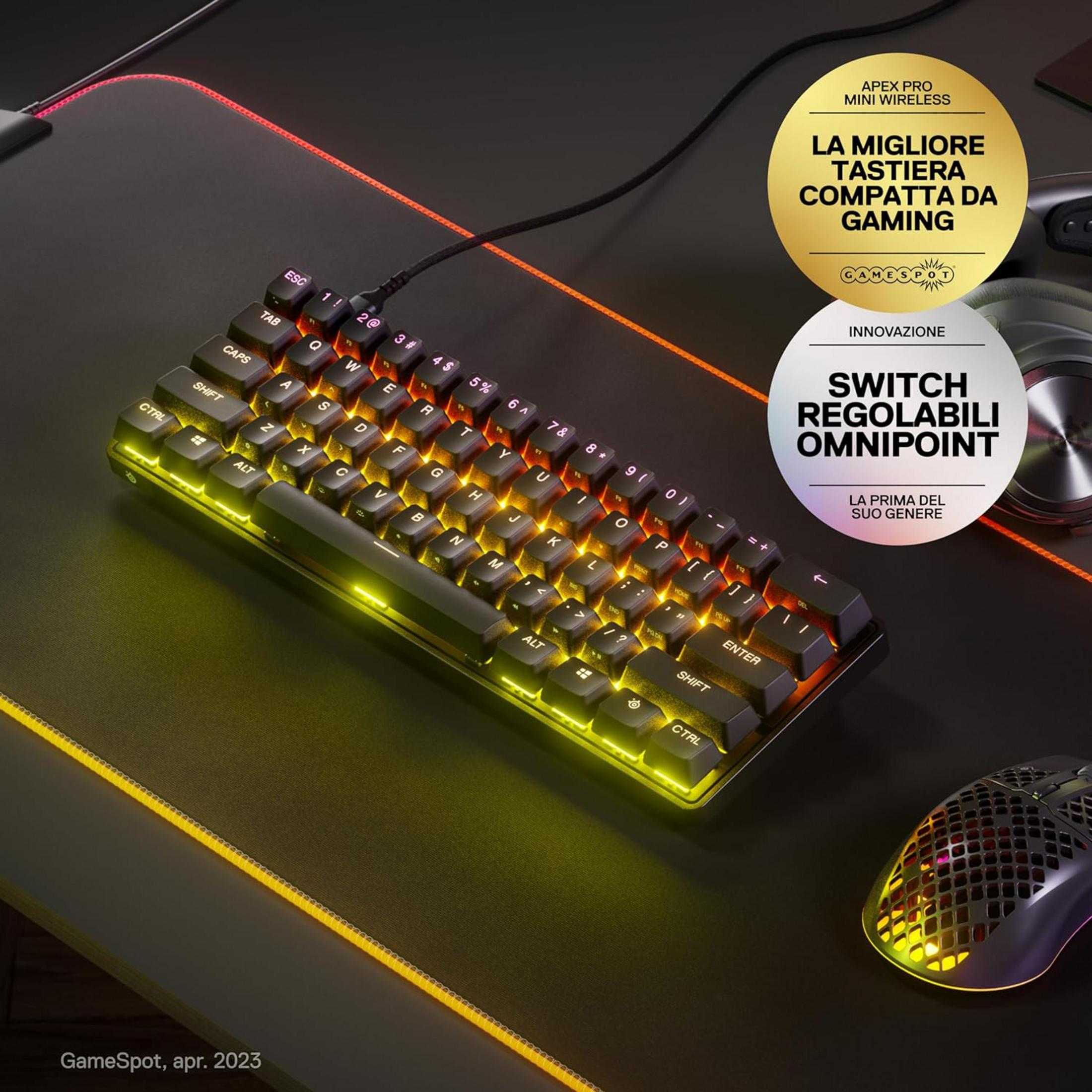 Una tastiera da gioco con illuminazione gialla e un mouse su una scrivania nera.