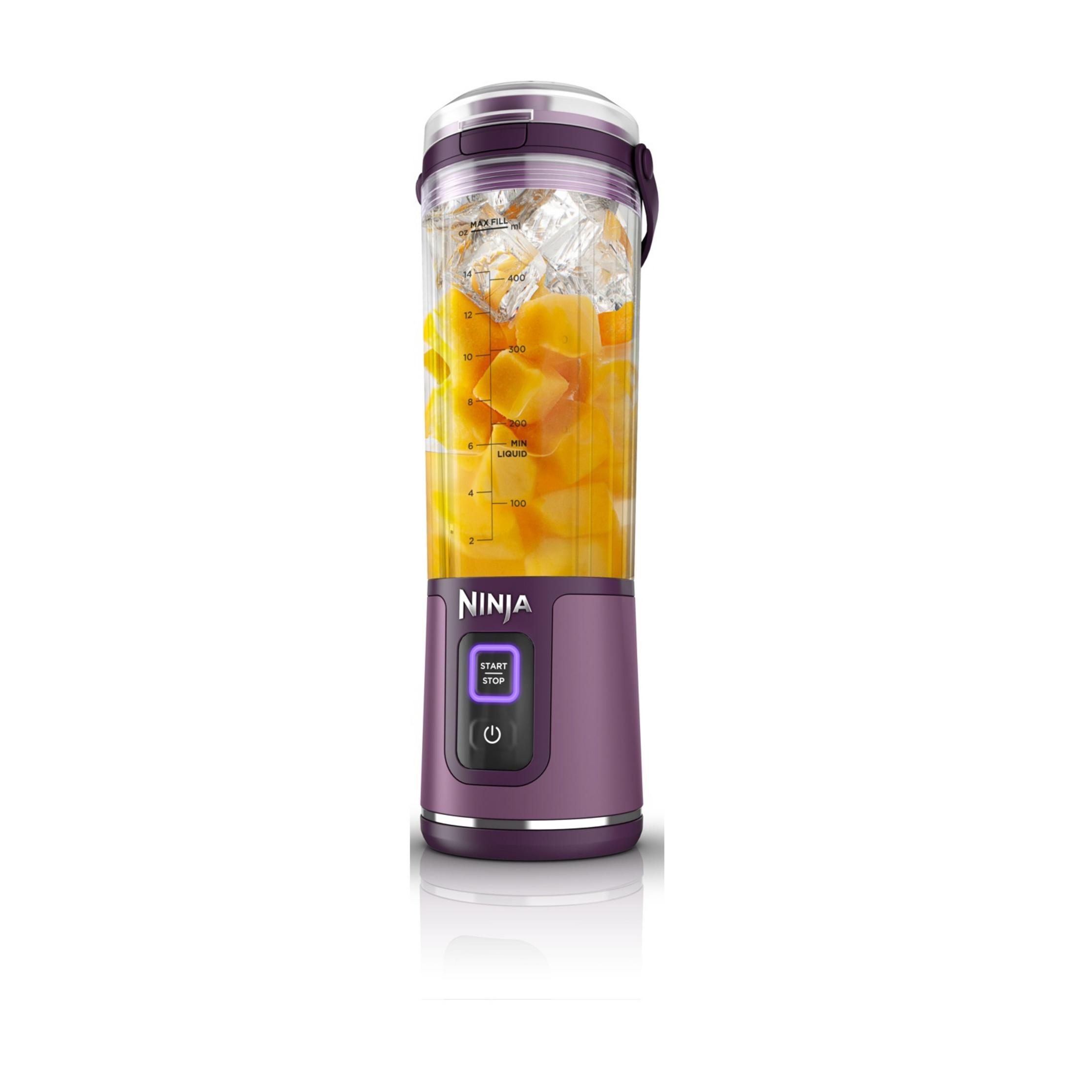Fioletowy blender Ninja wypełniony kostkami lodu i kawałkami pomarańczy.