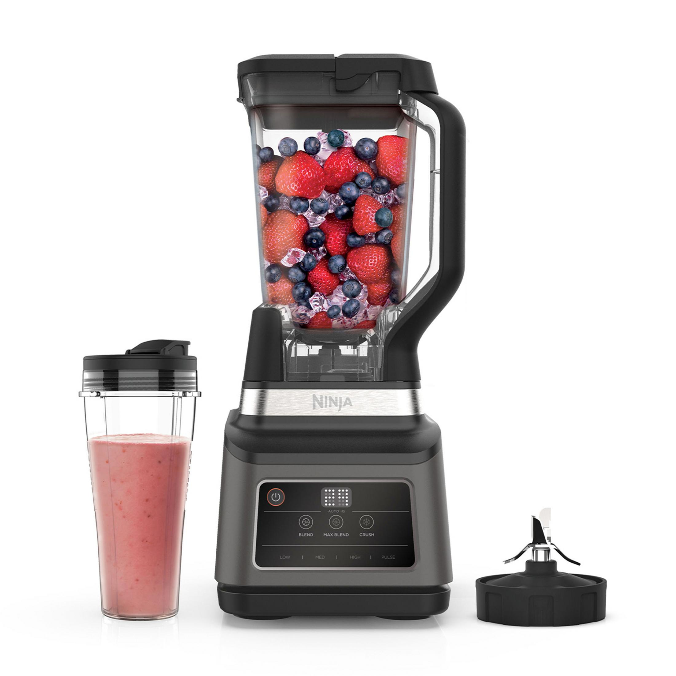 Blender Ninja z dzbankiem pełnym jagód i lodu, kubkiem smoothie i ostrzami.