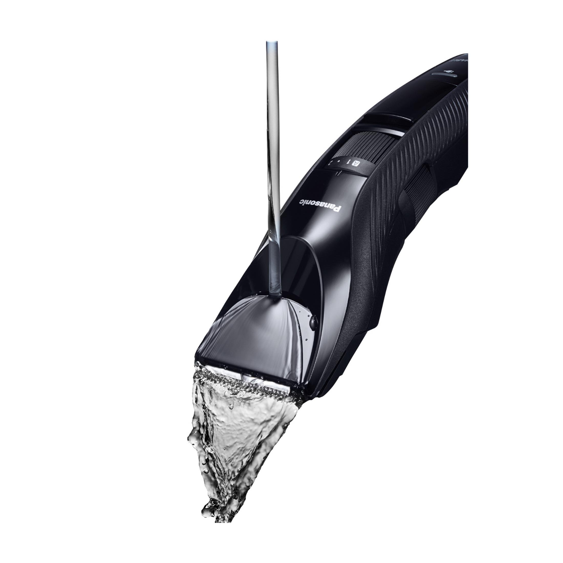 Ein schwarzer Panasonic-Trimmer wird unter einem Wasserstrahl gespült.