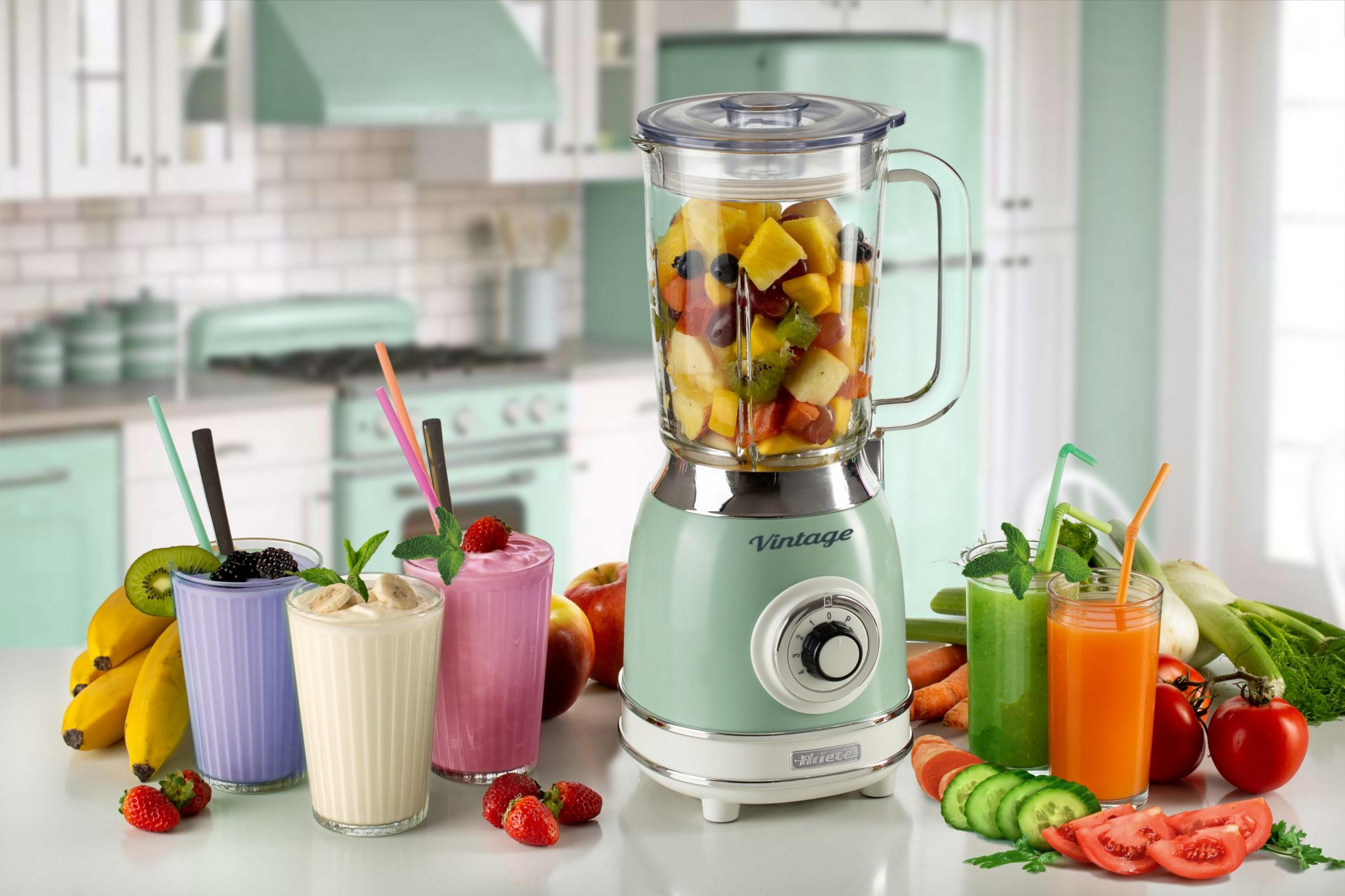 Een vintage blender met fruit en groenten, omringd door smoothies en sappen.