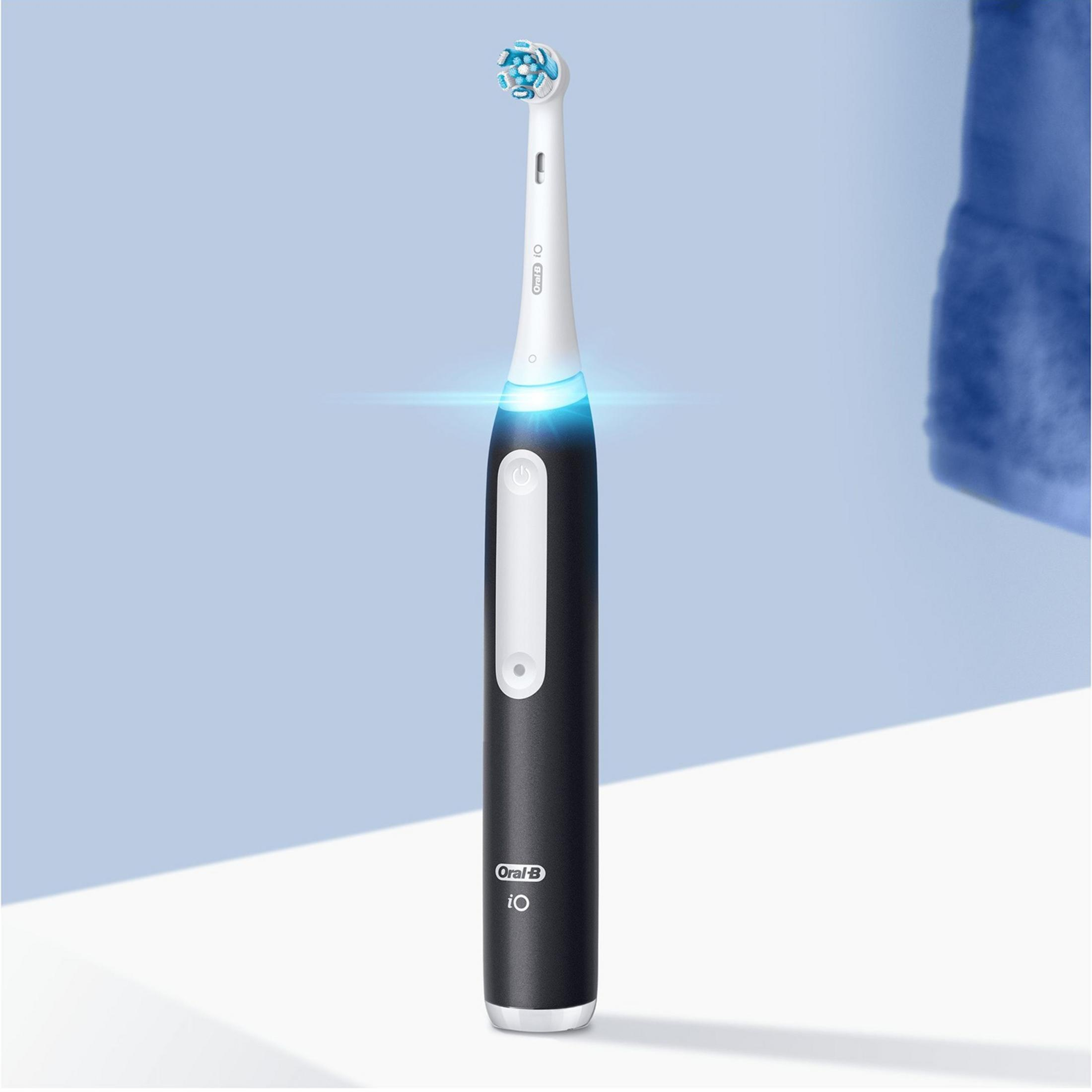 Een zwarte elektrische tandenborstel met blauw verlicht handvat.