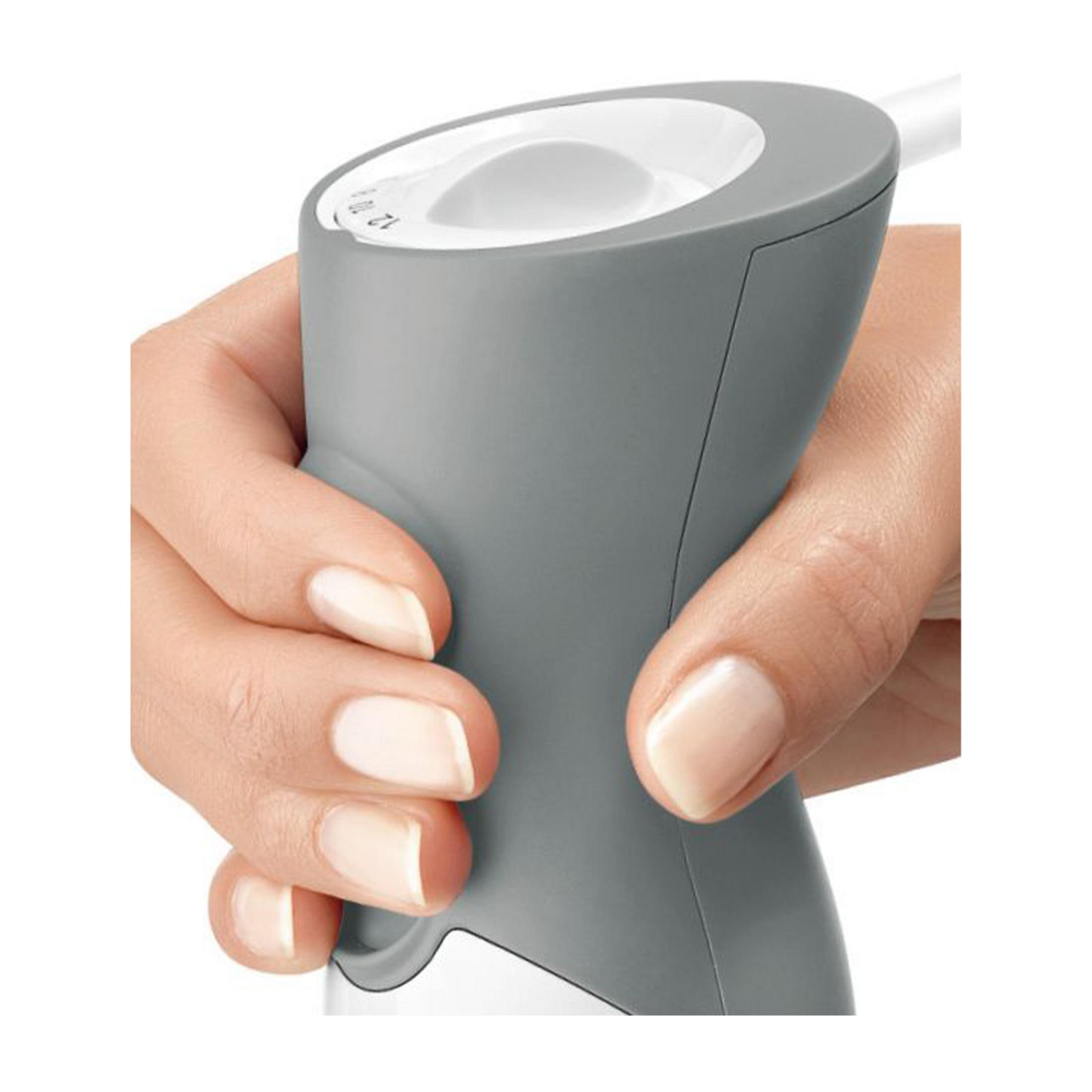 Dłoń trzyma szary uchwyt z białym przyciskiem i skalą.