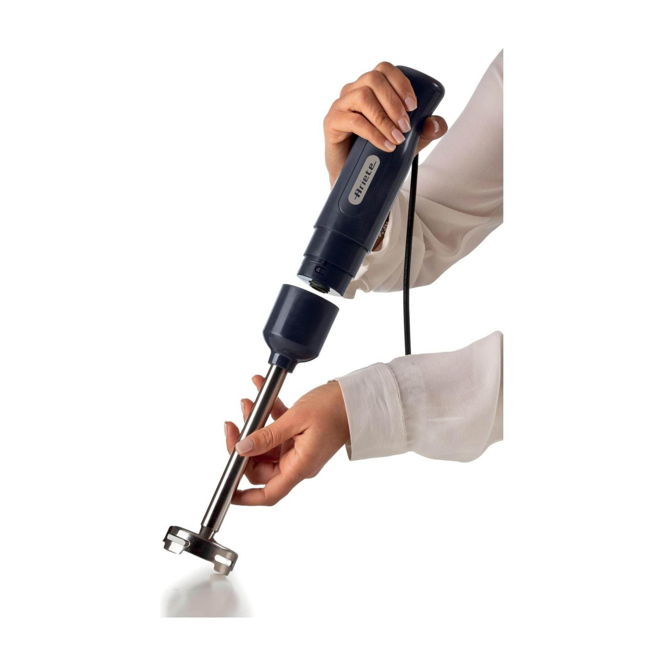 Dłoń trzyma ciemny blender ręczny ze stali nierdzewnej i odłączaną częścią.