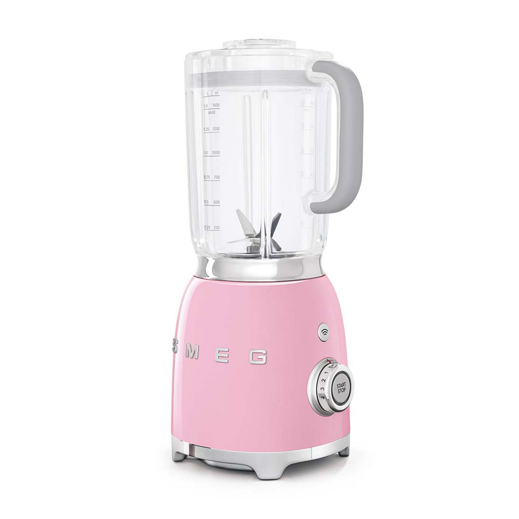 Una licuadora Smeg rosa con jarra transparente y controles plateados.