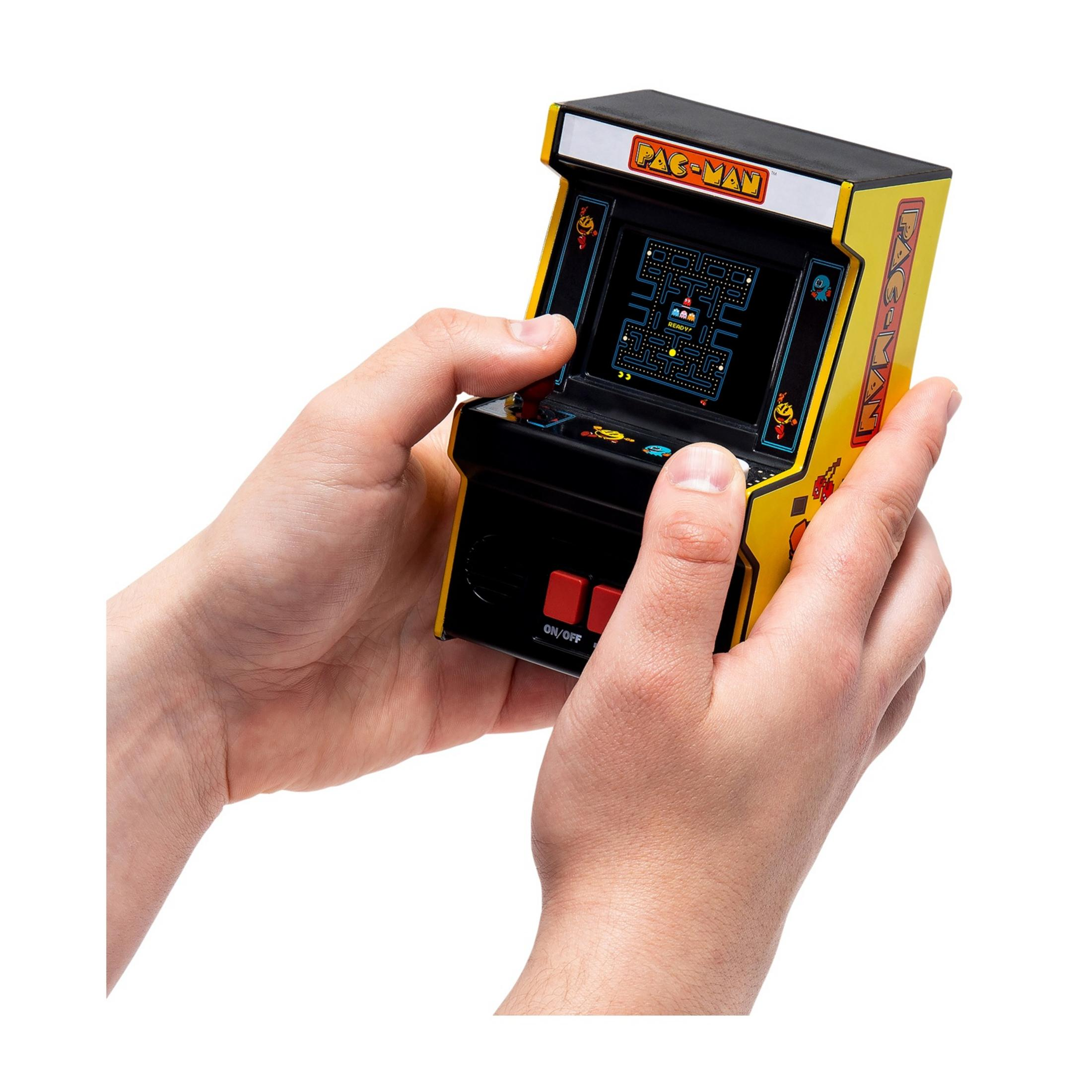 Mani tengono una macchinetta arcade Pac-Man gialla con il gioco sullo schermo.