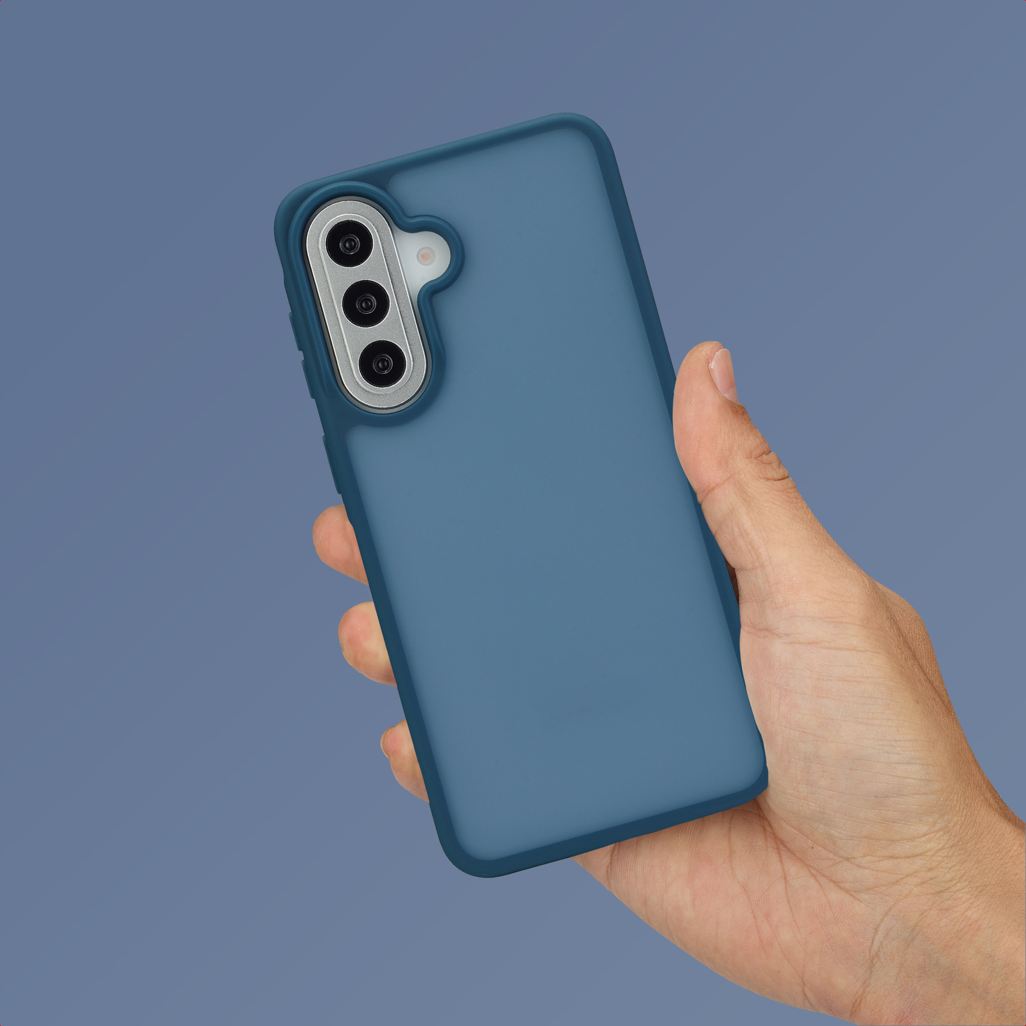 Een hand houdt een blauwe smartphone met drievoudige camera vast op blauwe achtergrond.
