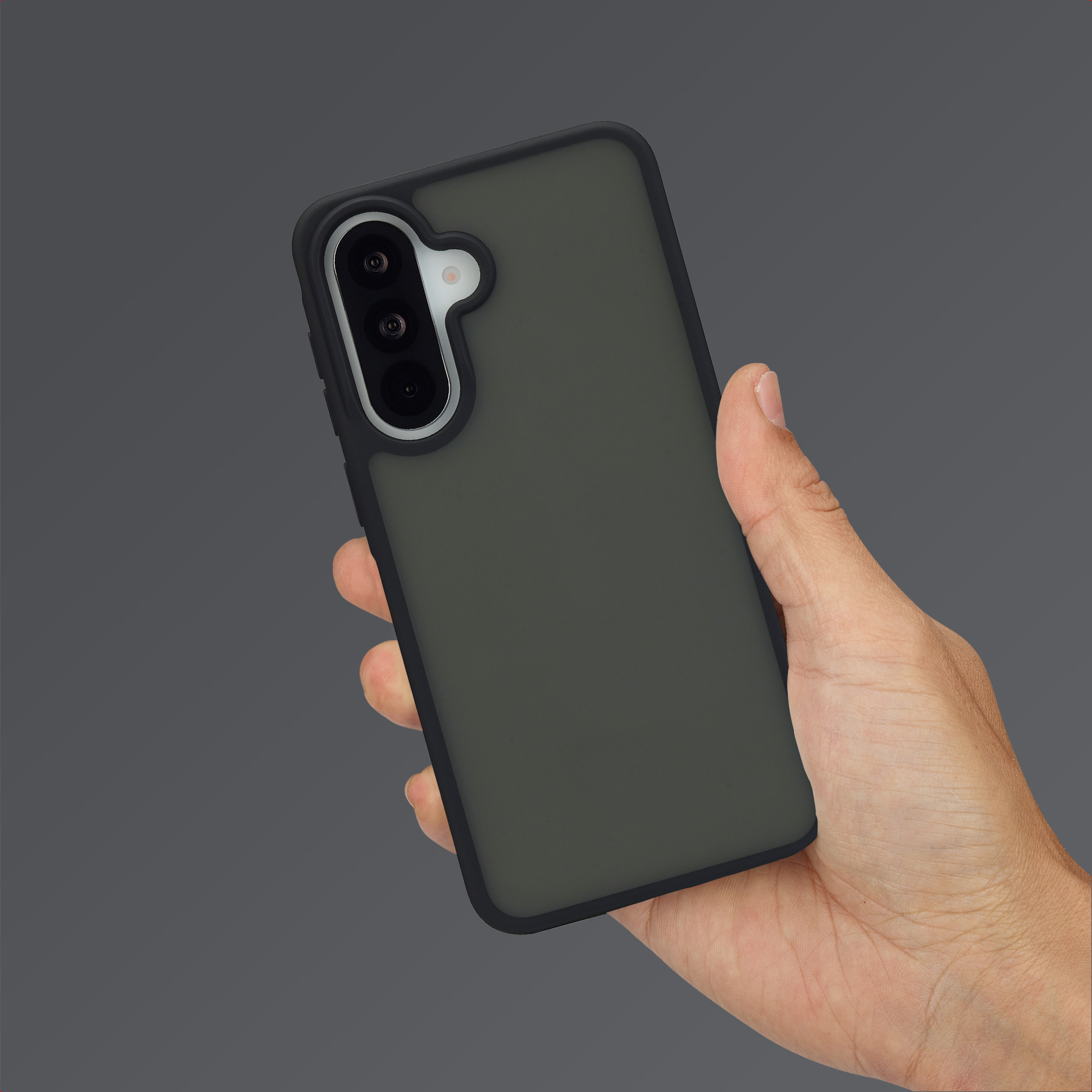Une main tient un smartphone sombre avec une configuration à triple caméra.
