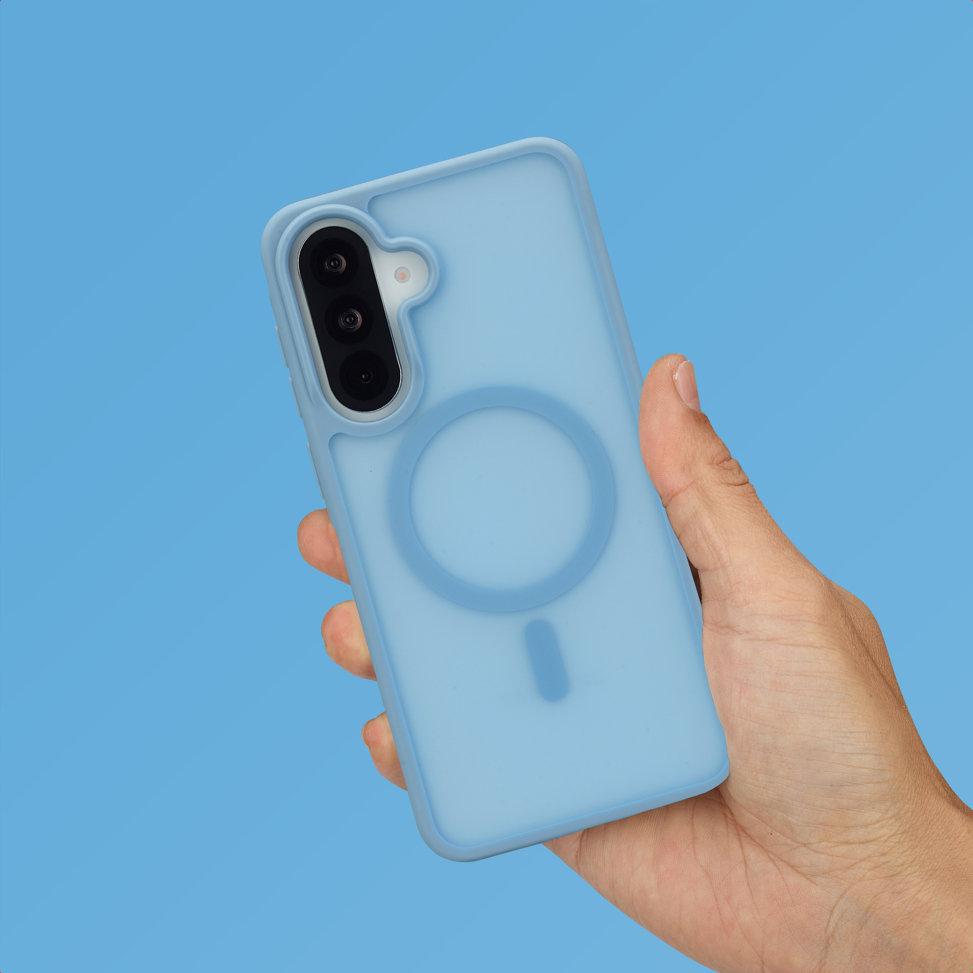 Une main tient un téléphone bleu clair avec un système de caméra et un anneau magnétique.