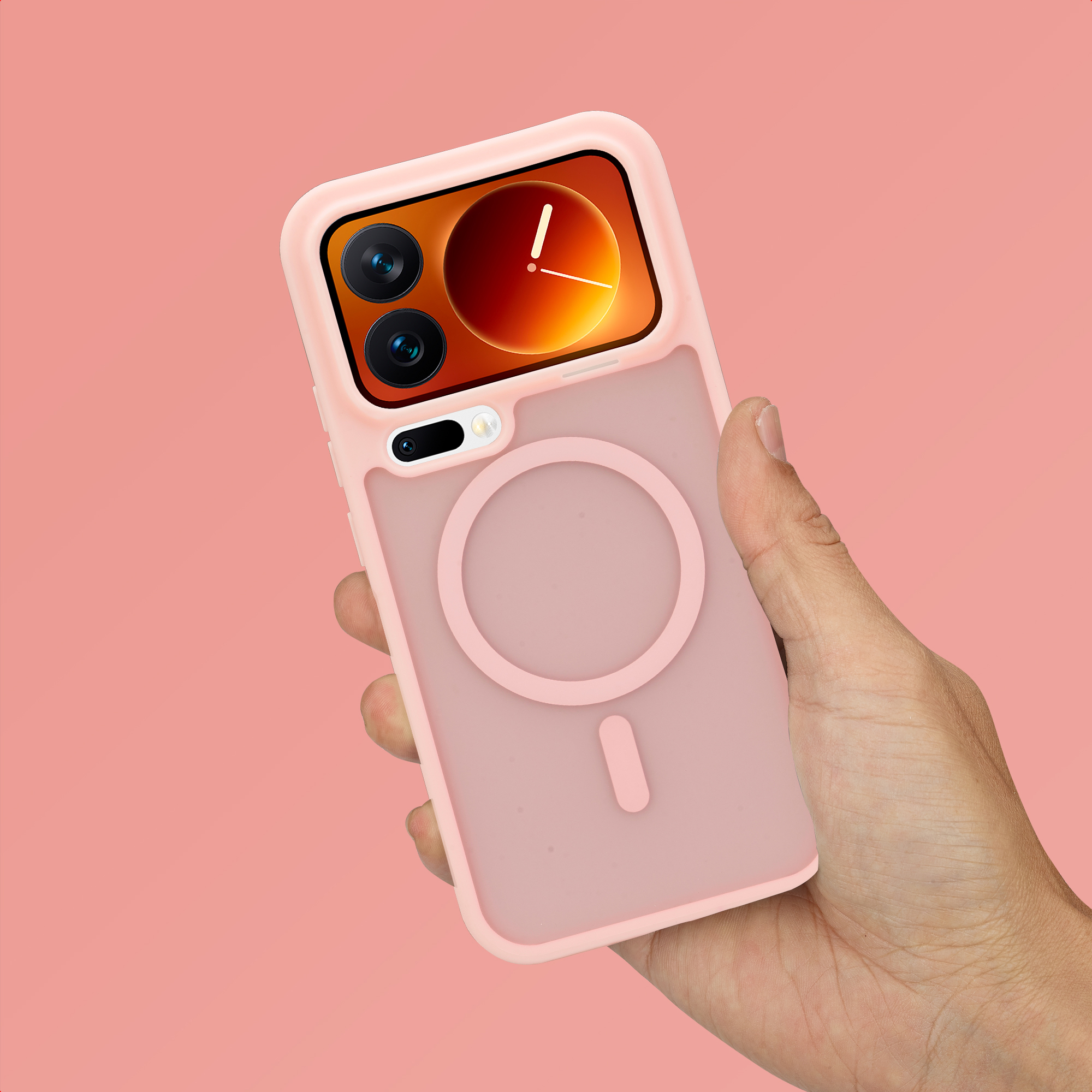 Een hand houdt een roze telefoonhoesje met magneetring vast op roze achtergrond.
