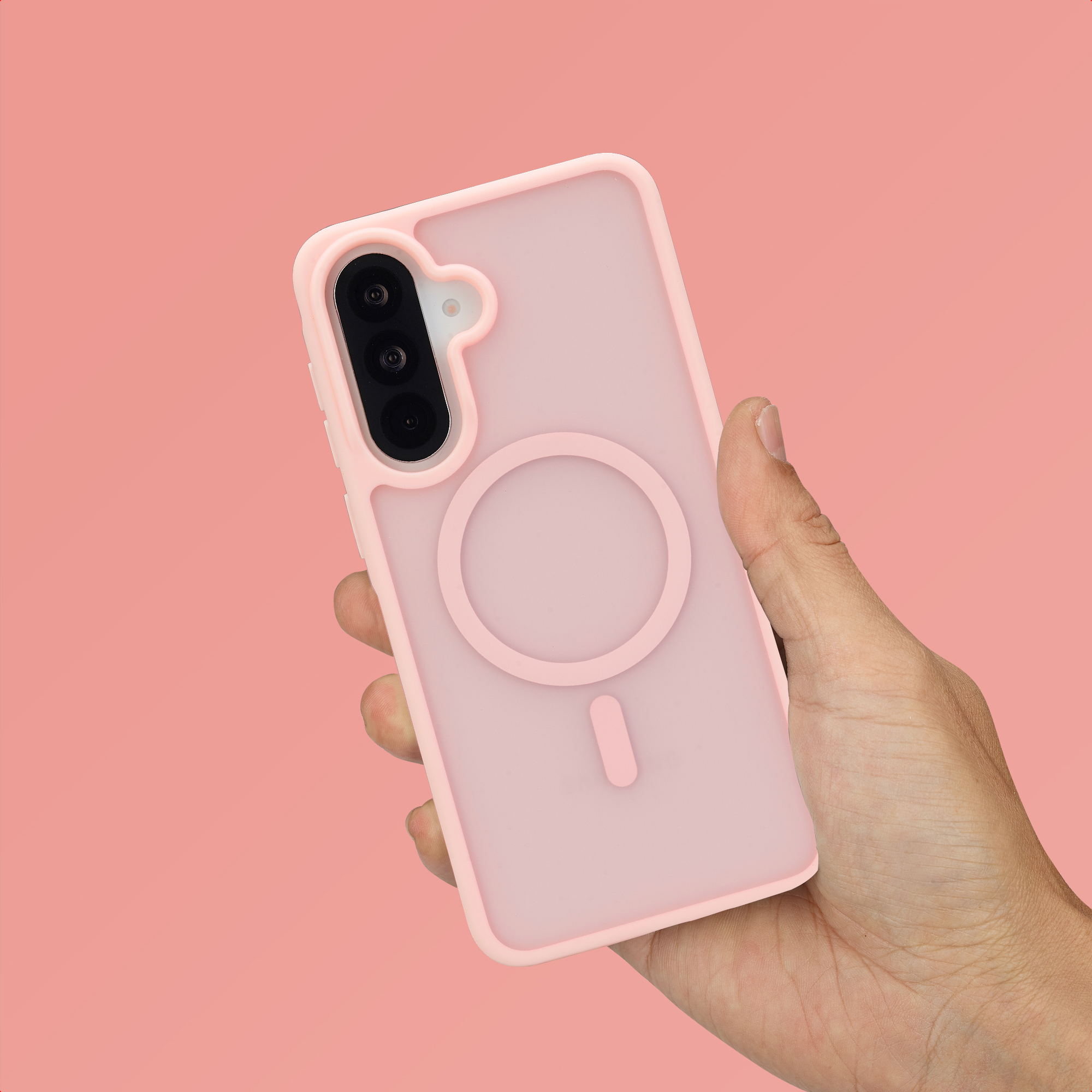 Een hand houdt een roze telefoonhoesje met magneetring vast tegen roze achtergrond.