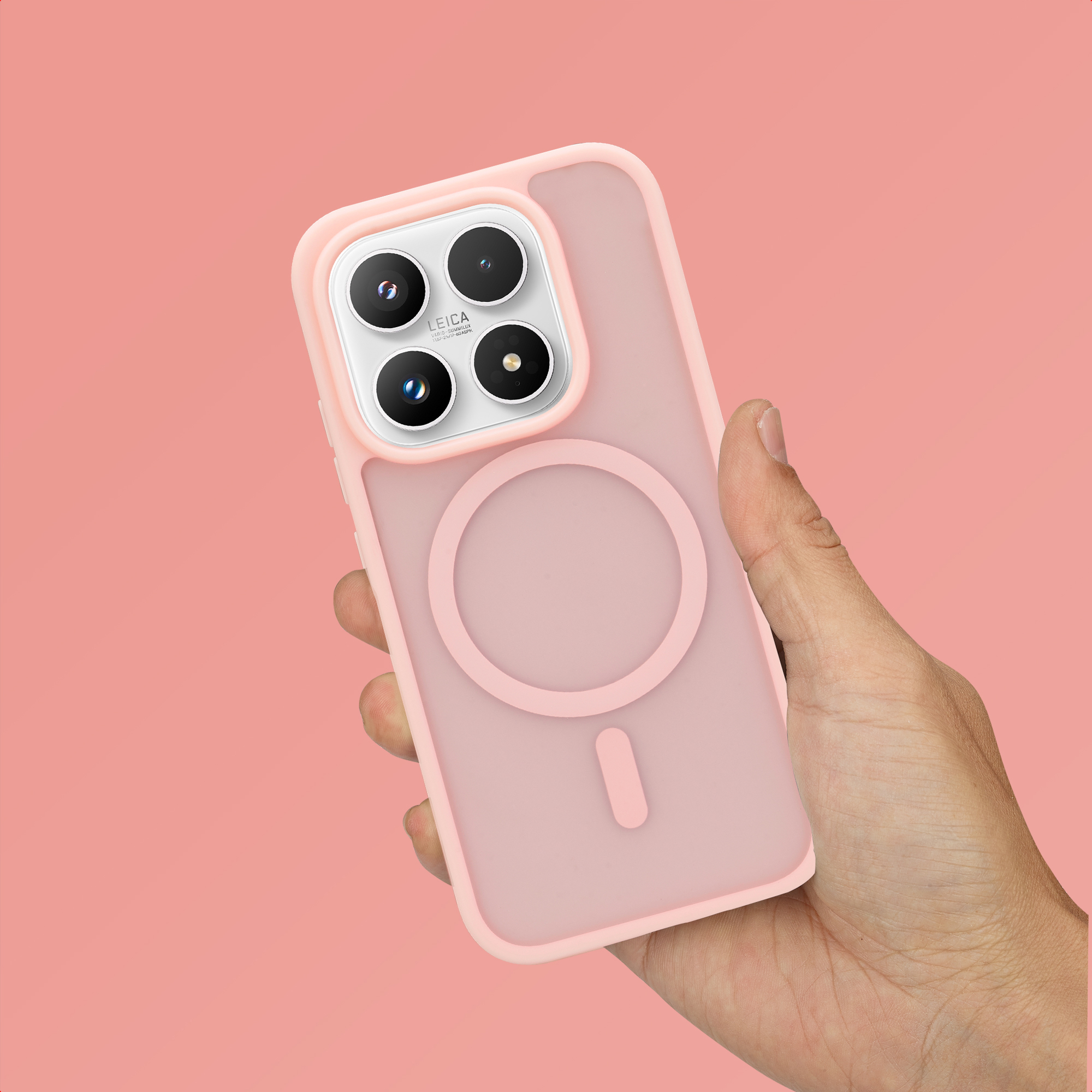Une main tient une coque de téléphone rose avec quatre objectifs et un anneau magnétique.