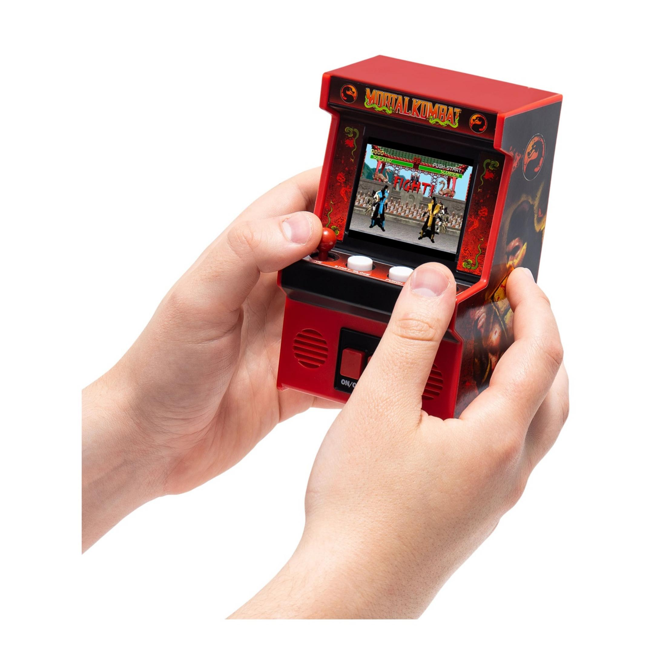 Una persona tiene un gioco arcade rosso in miniatura con Mortal Kombat sullo schermo.