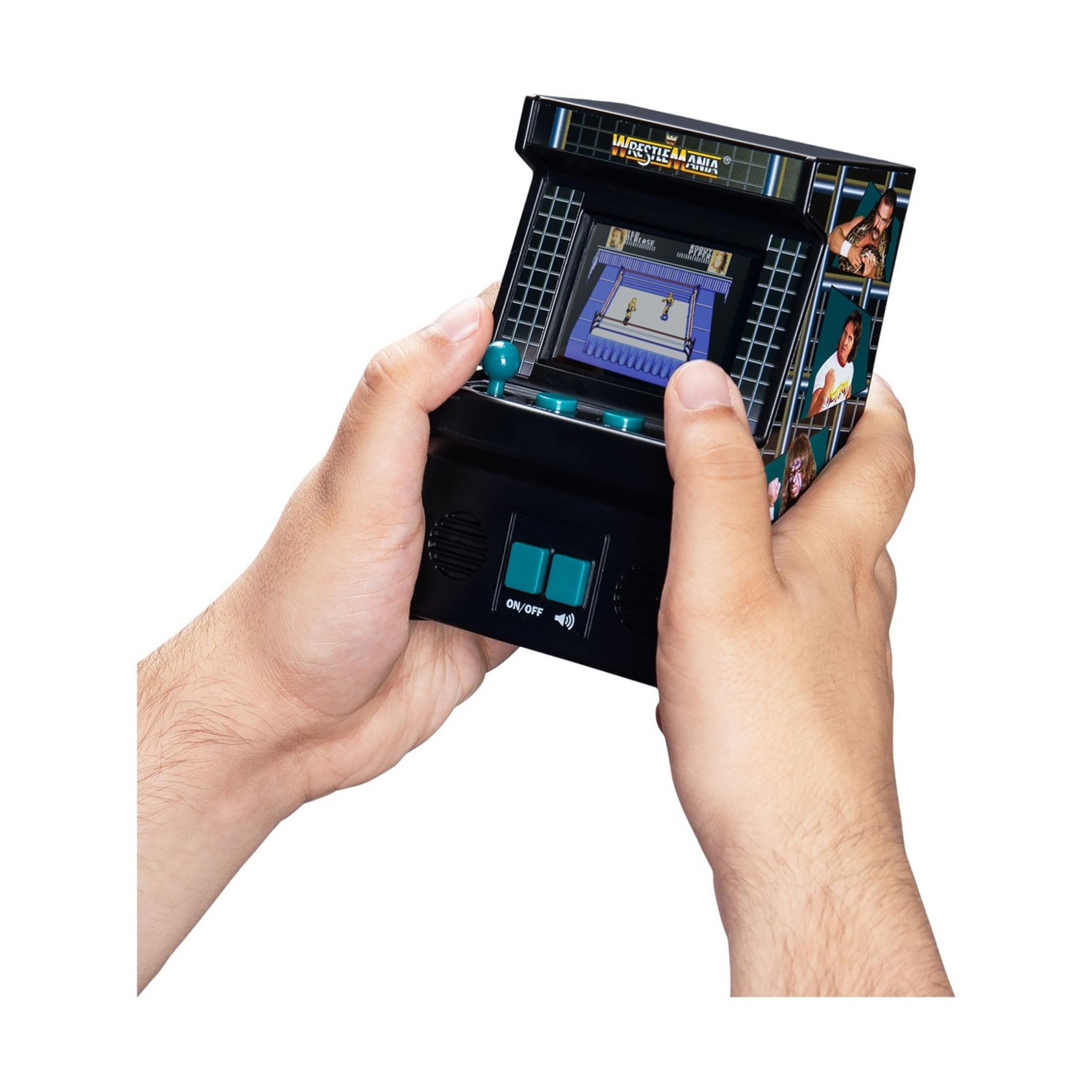 Persona gioca a un videogioco arcade di wrestling retrò su un piccolo dispositivo portatile nero.