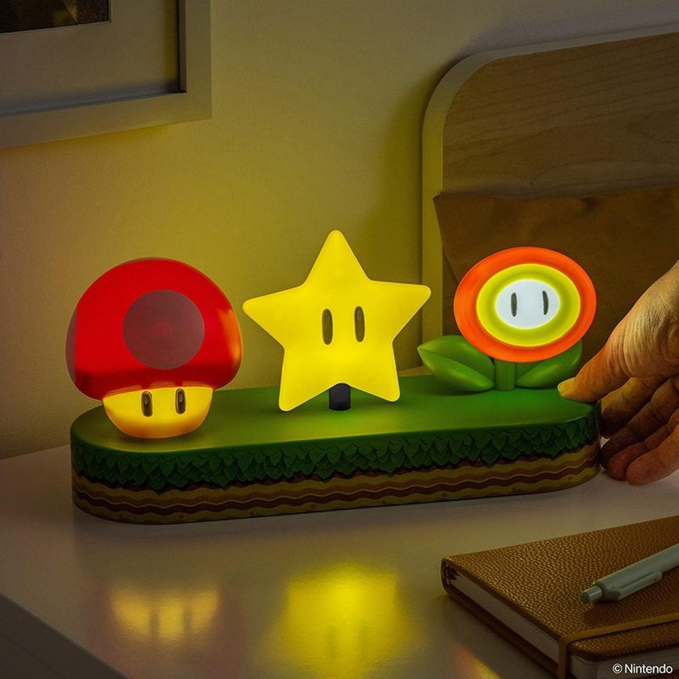 Lampade fungo, stella e fiore di Mario su base verde.