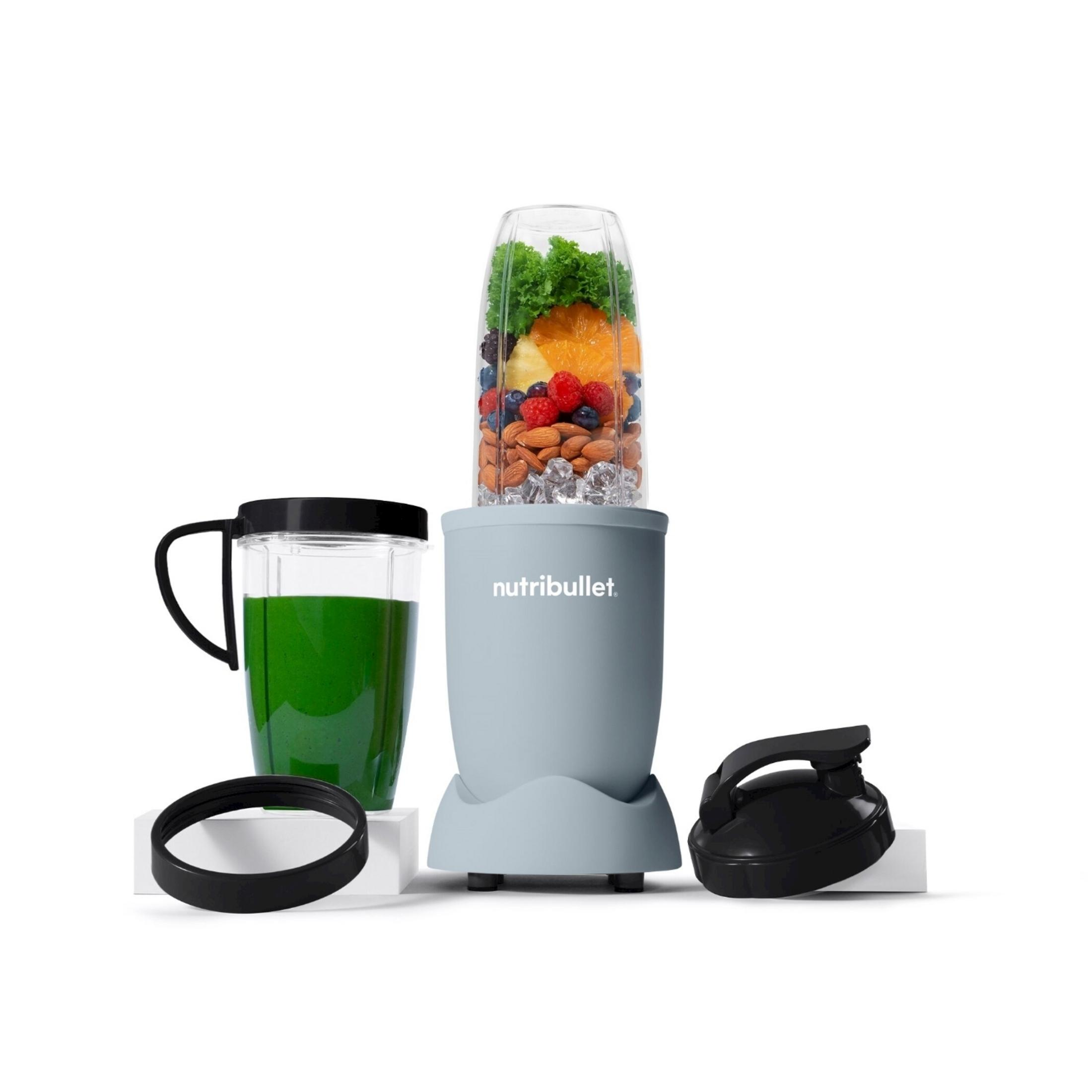 Un mixeur Nutribullet bleu clair avec des ingrédients tels que fruits, glace et verdure.