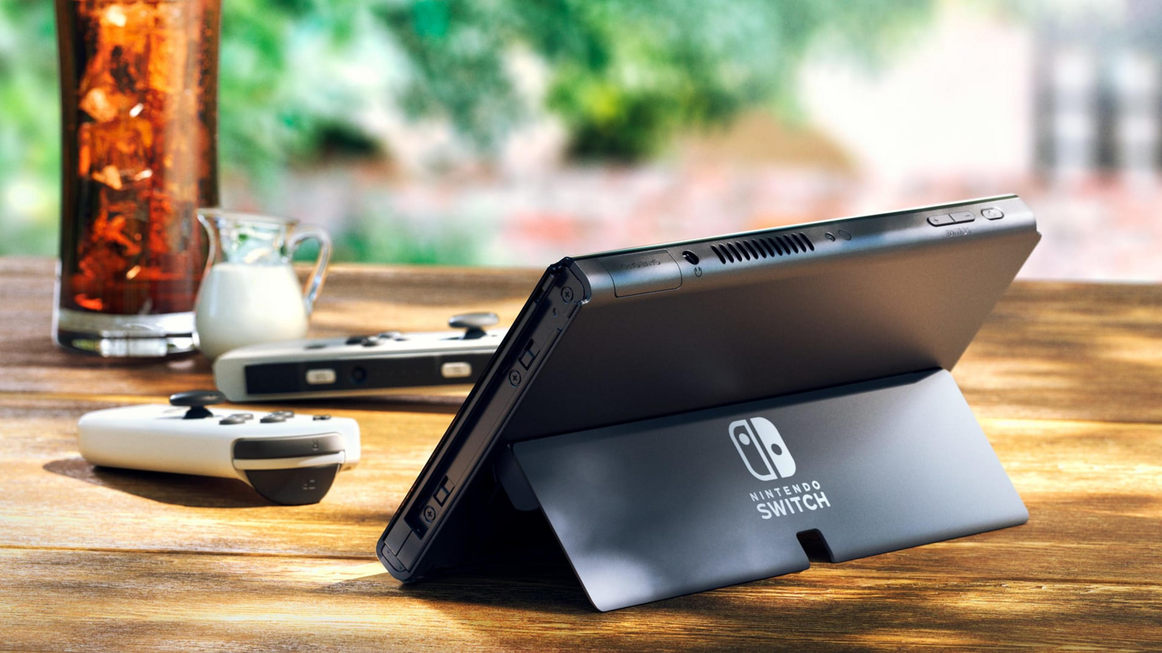 Nintendo Switch na drewnianym stole z napojami i kontrolerami.