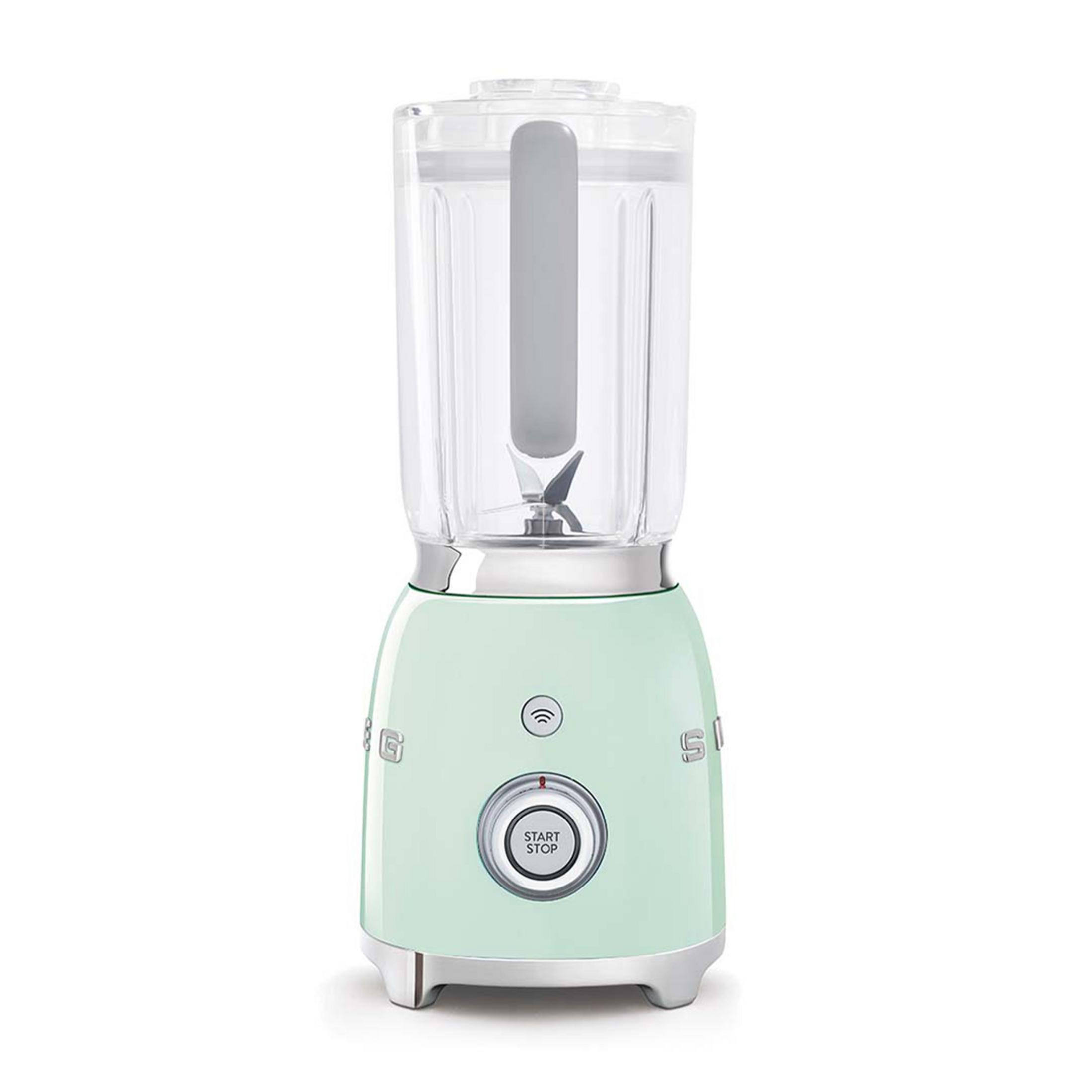 Un frullatore Smeg verde menta con caraffa trasparente e pulsante start/stop argentato.