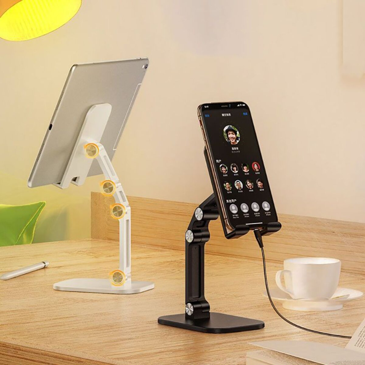 Ein Tablet und ein Smartphone stehen auf Schreibtischständern, ein Kabel ist angeschlossen.