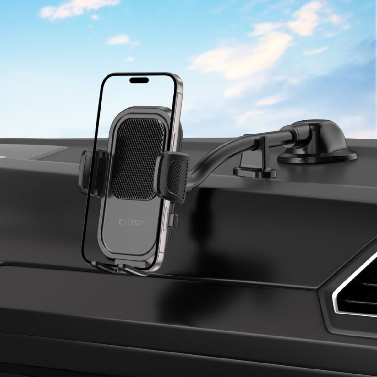 Ein Smartphone in einer schwarzen Autohalterung auf dem Armaturenbrett.