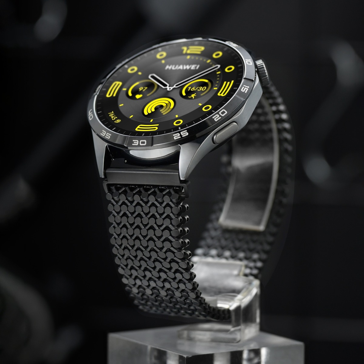 Eine graue Huawei Smartwatch mit schwarzem Mesh-Armband auf einem Displayständer.
