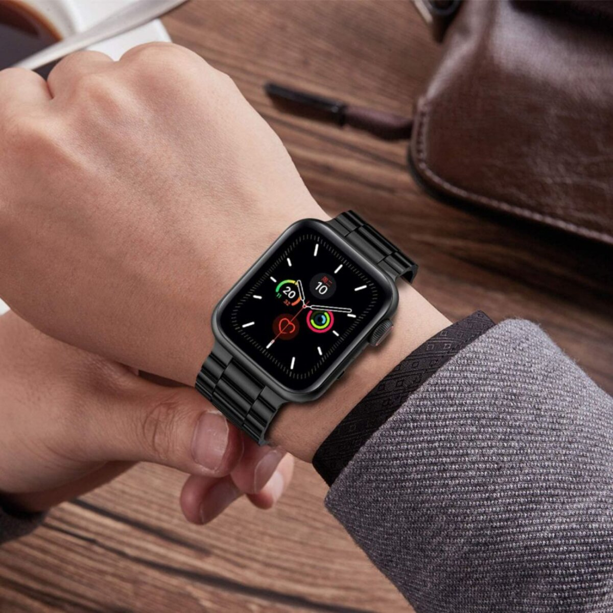 Schwarze Smartwatch mit Metallarmband am Handgelenk, zeigt Gesundheitsdaten an.