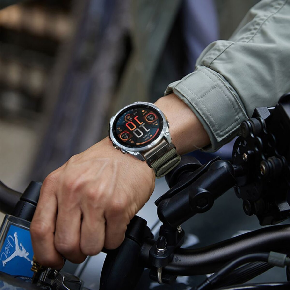 Ein Mann trägt eine Smartwatch am Handgelenk, die an einem Motorrad befestigt ist.