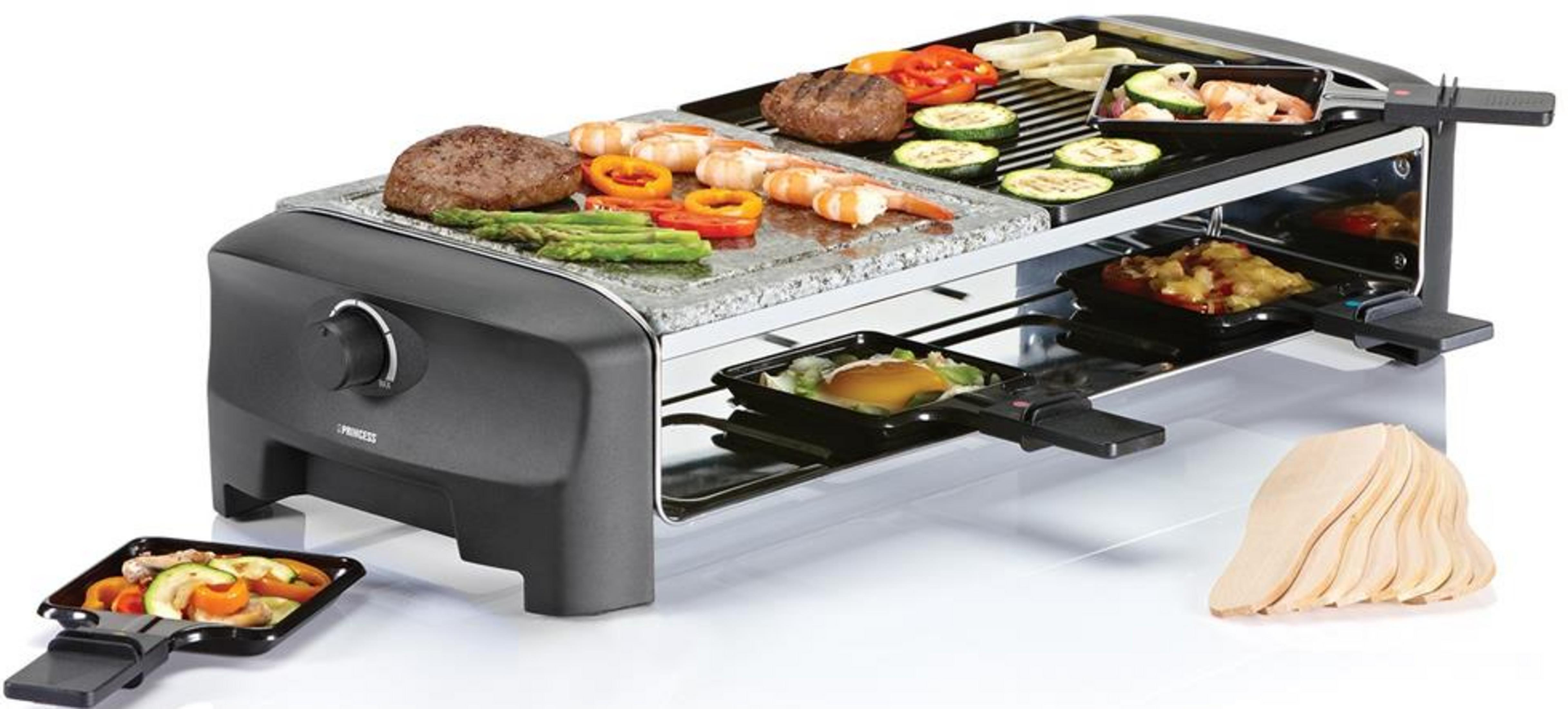 Ein Raclettegerät mit gegrillten Speisen, Fleisch, Garnelen, Gemüse und Pfännchen.